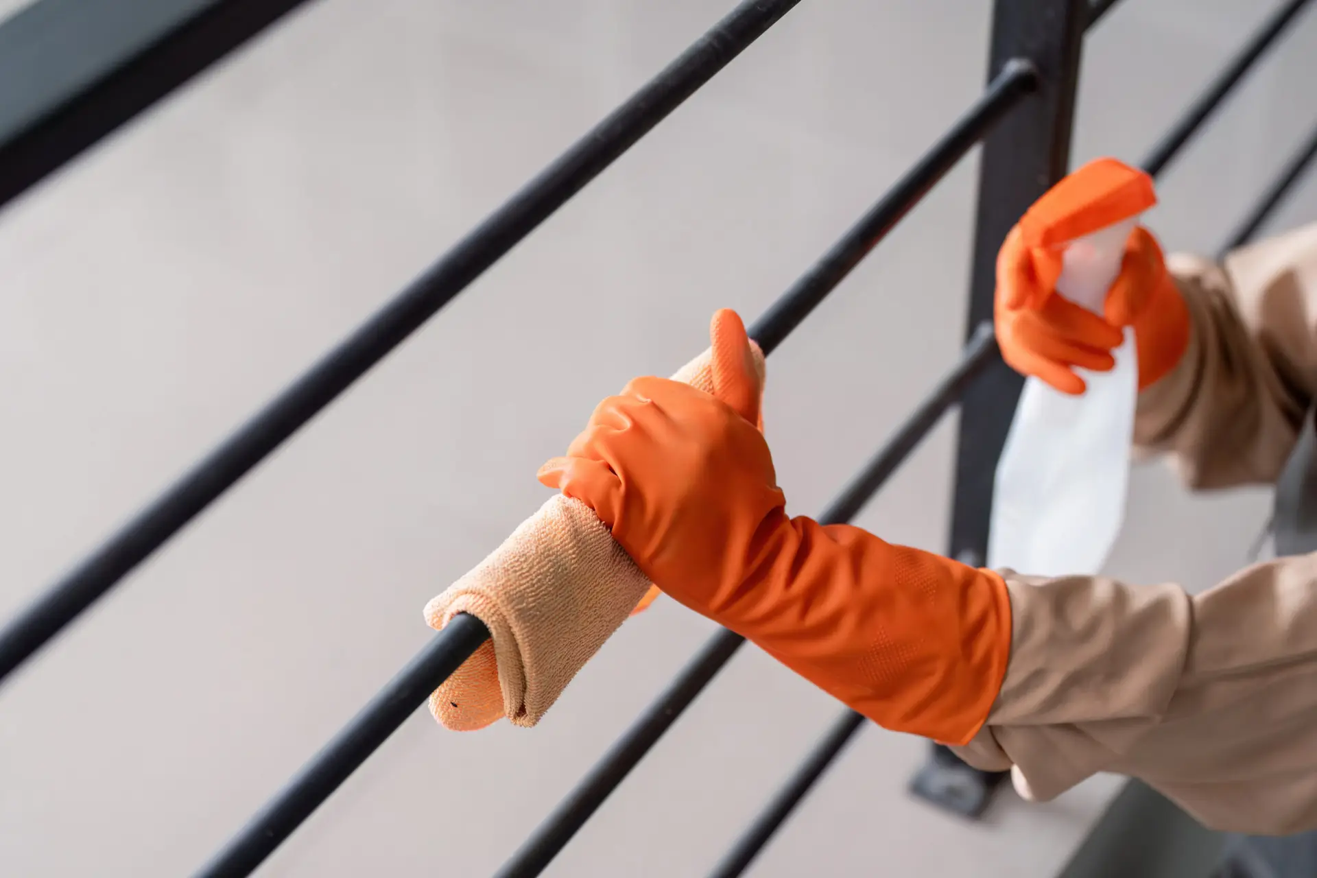 An Urgent Pro bond cleaning provider in Gold Coast cleaning large windows and wiping down balcony surfaces of a Gold Coast rental apartment, with professional equipment visible in a realistic local service setting