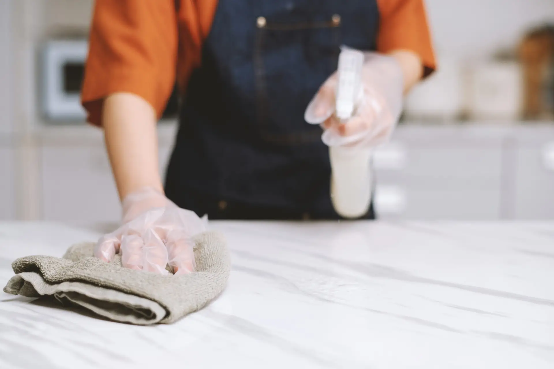 An Urgent Pro bond cleaning provider in Gold Coast cleaning the complete kitchen of a Gold Coast rental including benchtops, oven and sink for a bond cleaning service, with professional equipment visible in a realistic local service setting