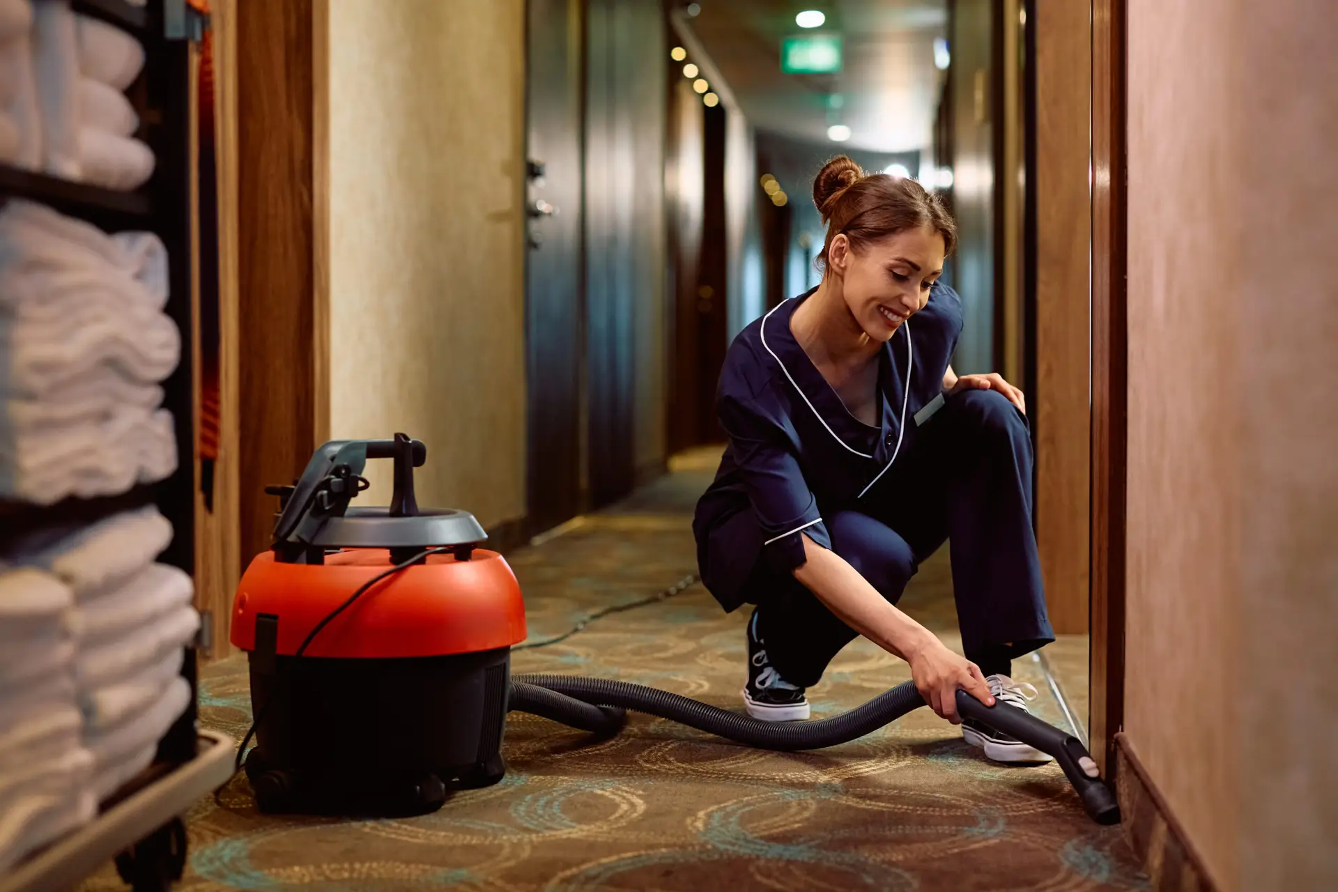 An Urgent Pro carpet cleaning provider in Brisbane working methodically in rows across a large carpeted living area, with professional equipment visible in a realistic local service setting