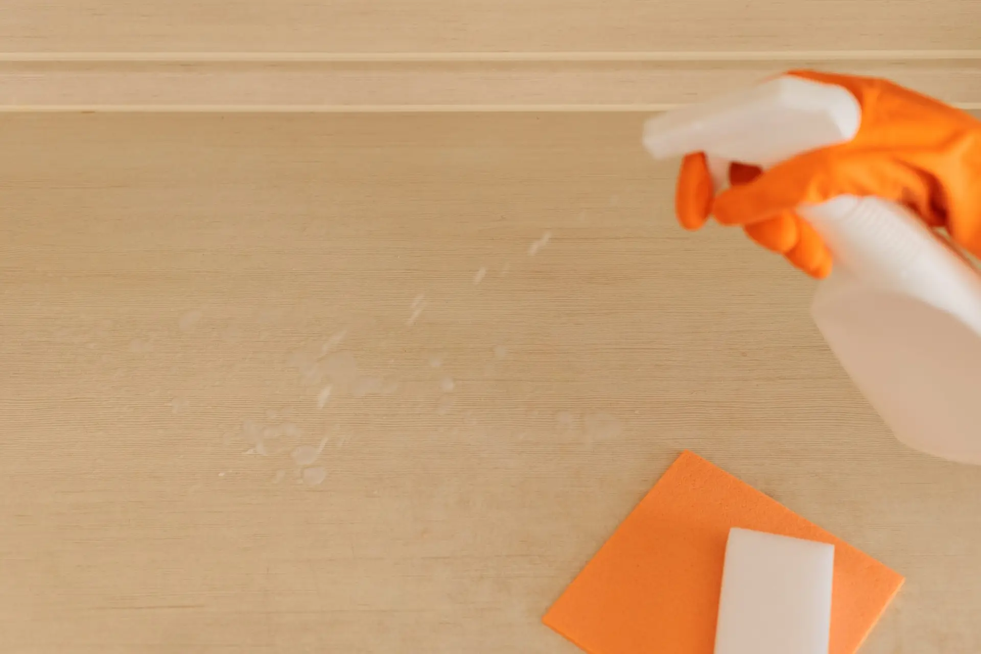 An Urgent Pro carpet cleaning provider in Melbourne applying a pre-treatment spray to a visible carpet stain before steam cleaning, with professional equipment visible in a realistic local service setting