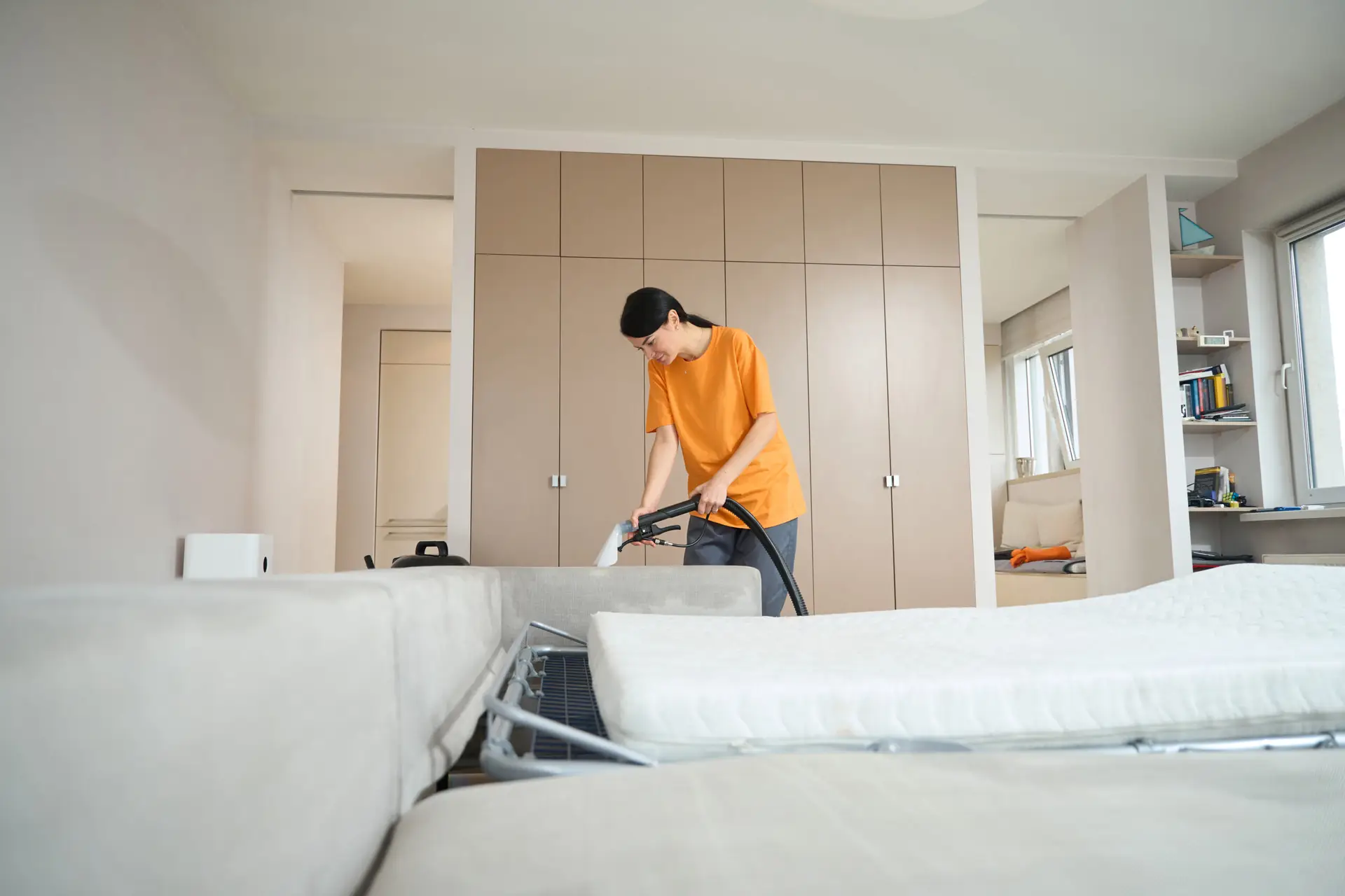 An Urgent Pro carpet cleaning provider in Perth working methodically in rows across a large carpeted living area, with professional equipment visible in a realistic local service setting
