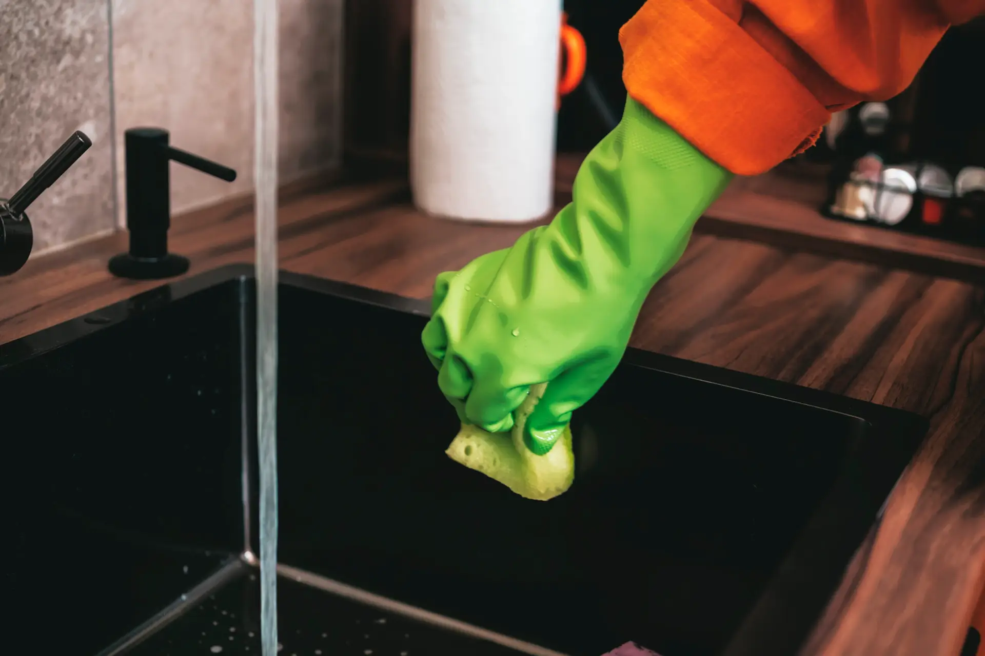 An Urgent Pro end of lease cleaning provider in Melbourne scrubbing the kitchen sink, benchtops and cupboard doors in a Melbourne rental in preparation for the end of lease inspection, with professional equipment visible in a realistic local service setting