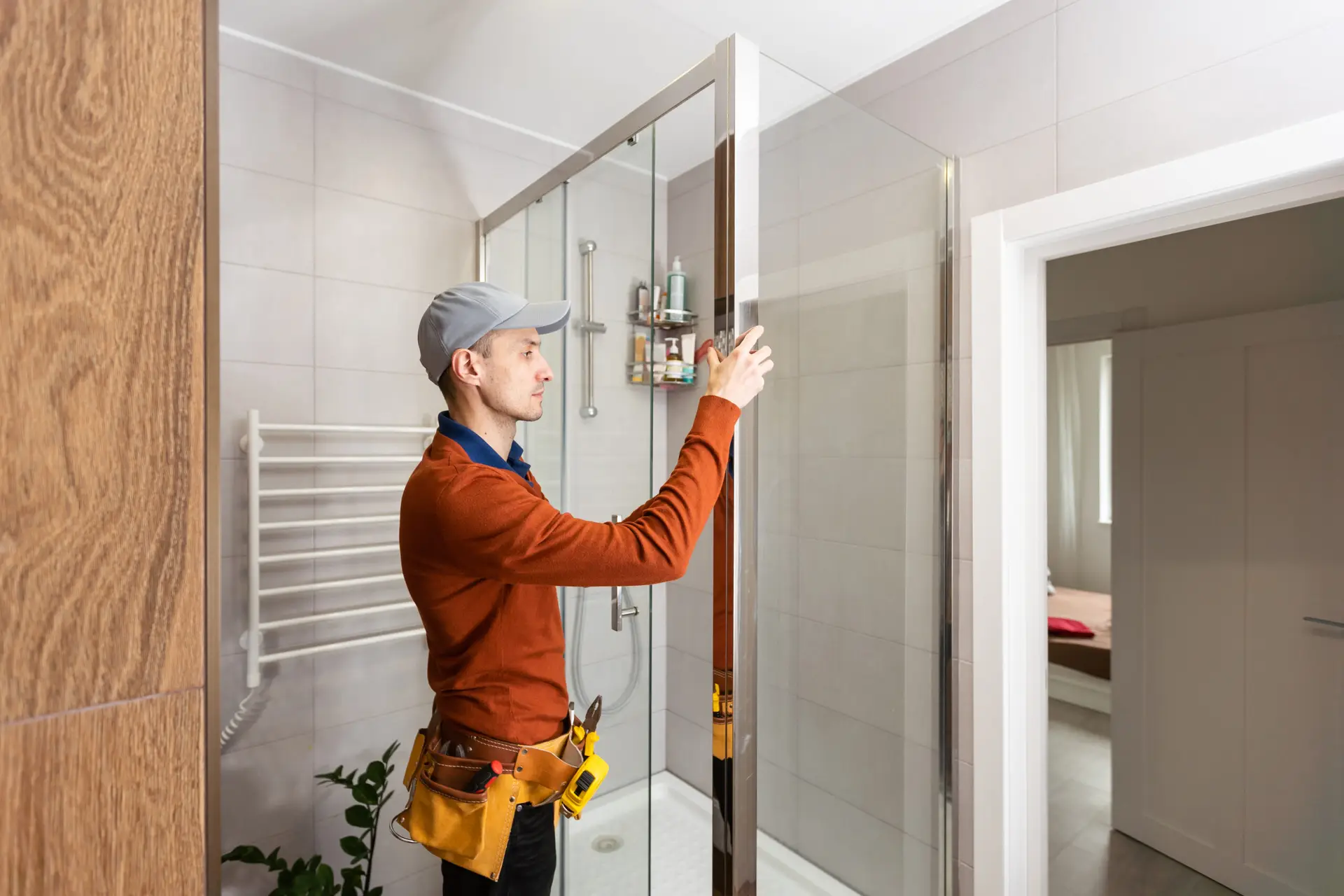 An Urgent Pro handyman provider in Gold Coast adjusting sticking door hinges and planing a swollen door frame to allow smooth opening, with professional equipment visible in a realistic local service setting