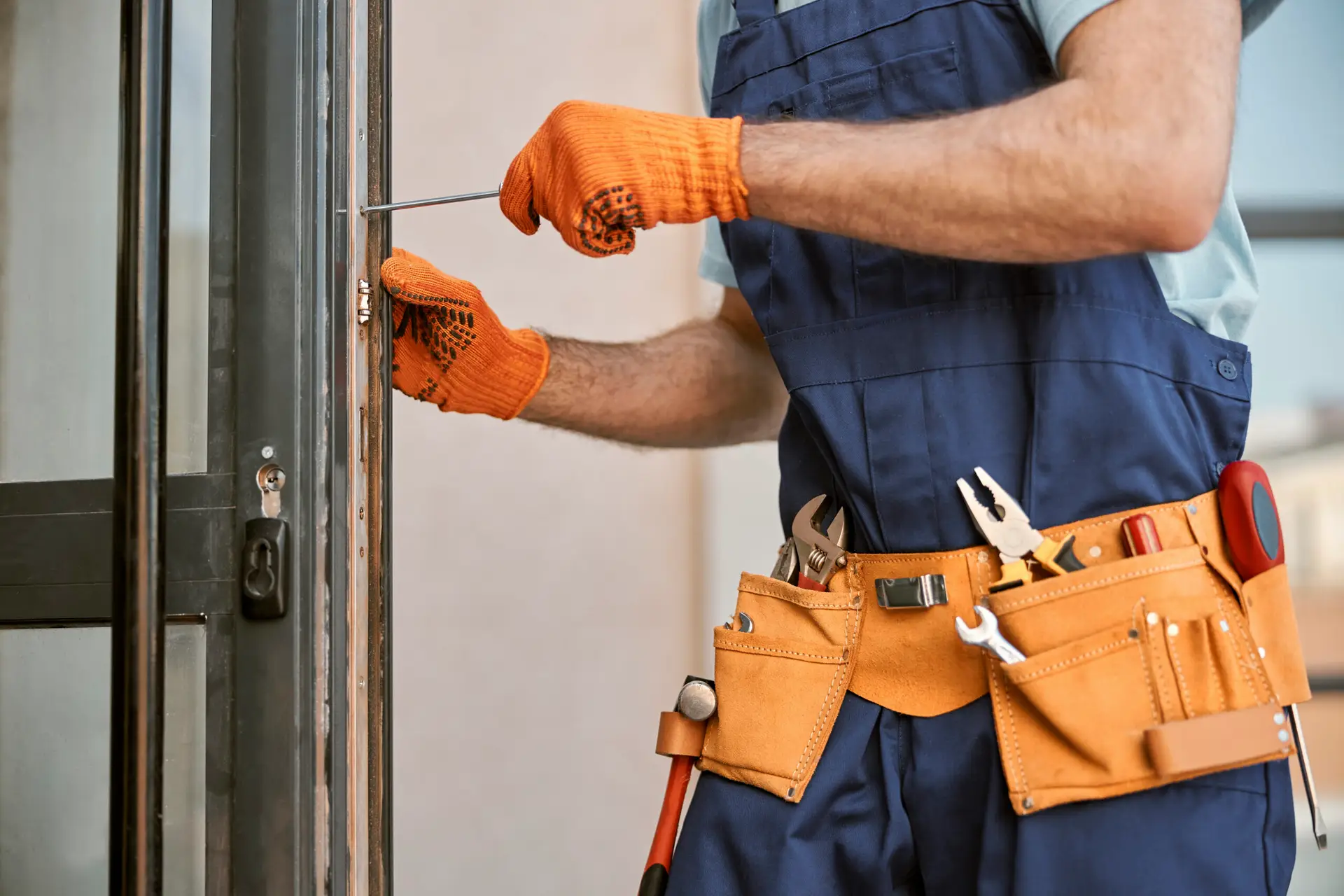 An Urgent Pro handyman provider in Melbourne adjusting sticking door hinges and planing a swollen door frame to allow smooth opening, with professional equipment visible in a realistic local service setting
