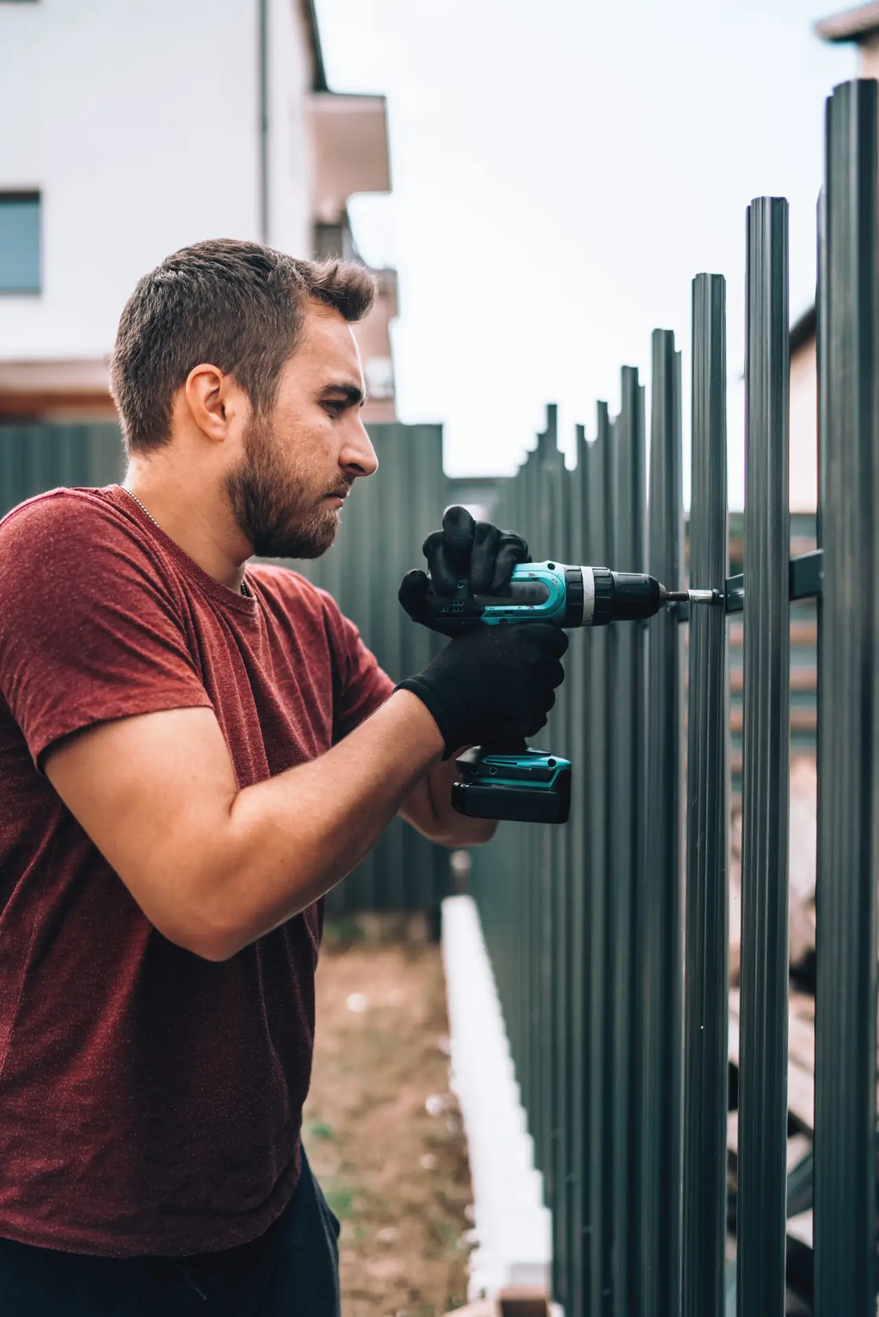 An Urgent Pro handyman provider in Melbourne repairing a damaged fence paling and securing a loose post with a drill and treated timber, with professional equipment visible in a realistic local service setting