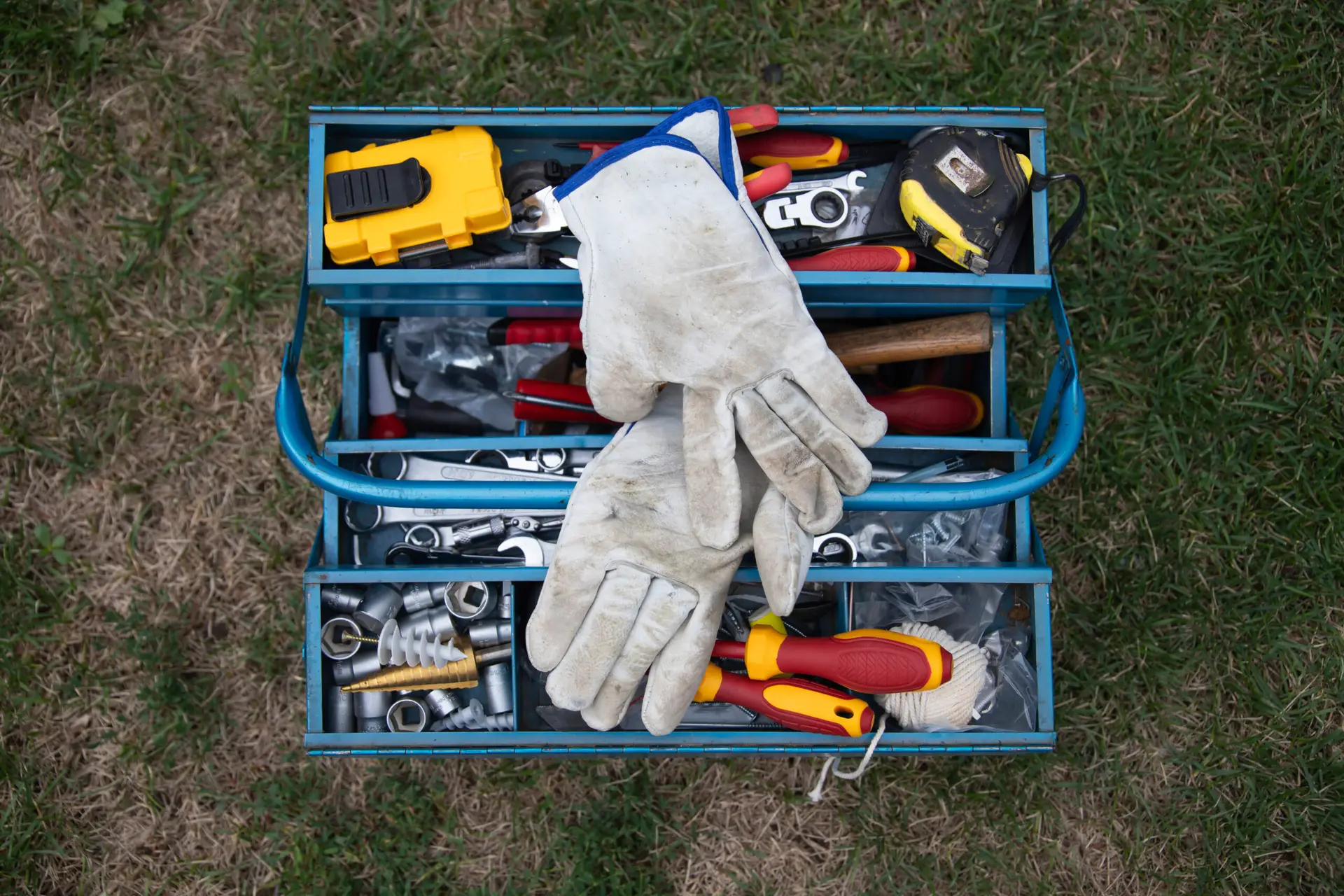 An Urgent Pro handyman provider in Melbourne laying out a professional handyman toolkit including drill, level, spanners and drill bits, with professional equipment visible in a realistic local service setting