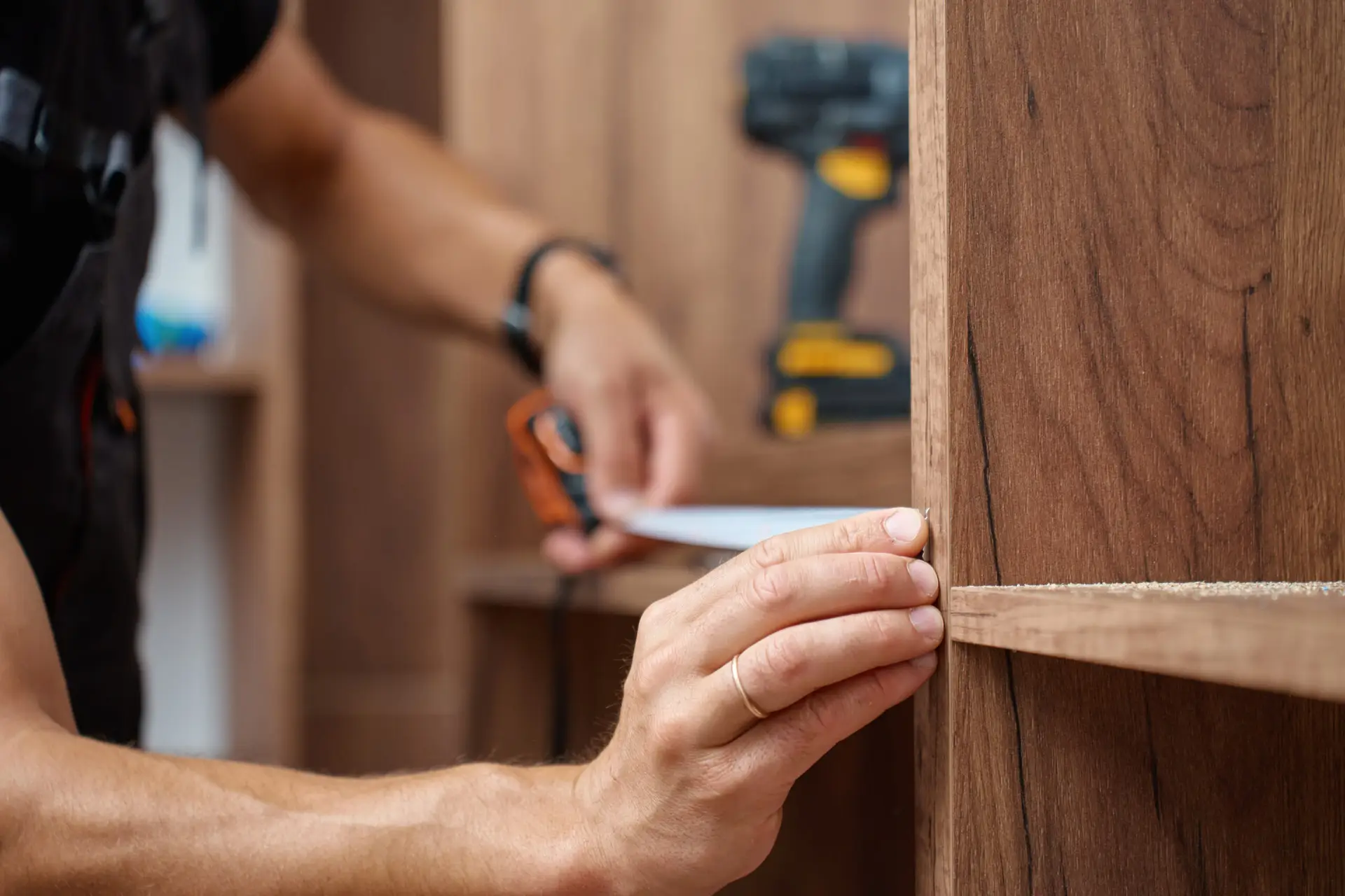 An Urgent Pro handyman provider in Perth assembling a flat-pack wardrobe following the instruction sheet with a mallet and Allen key, with professional equipment visible in a realistic local service setting