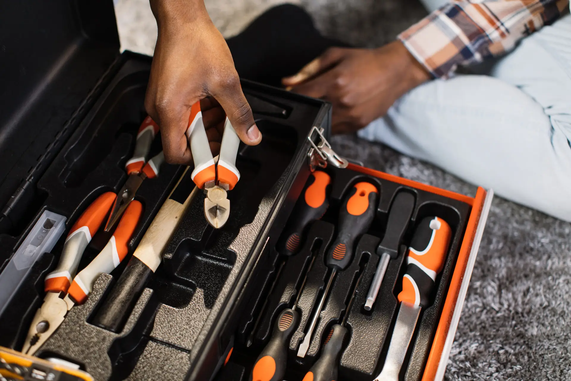 An Urgent Pro handyman provider in Perth laying out a professional handyman toolkit including drill, level, spanners and drill bits, with professional equipment visible in a realistic local service setting