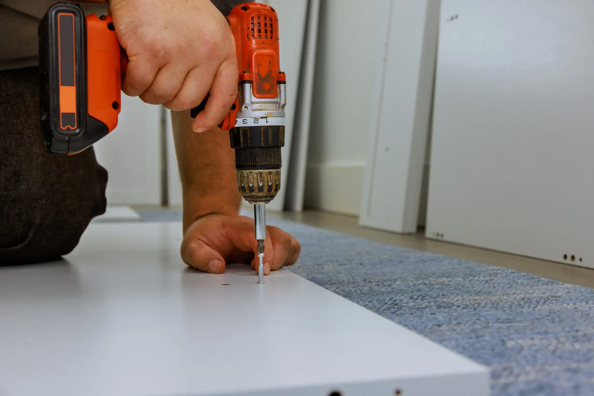 An Urgent Pro handyman provider in Sydney measuring, drilling and installing floating wall shelves with a spirit level and wall anchors, with professional equipment visible in a realistic local service setting