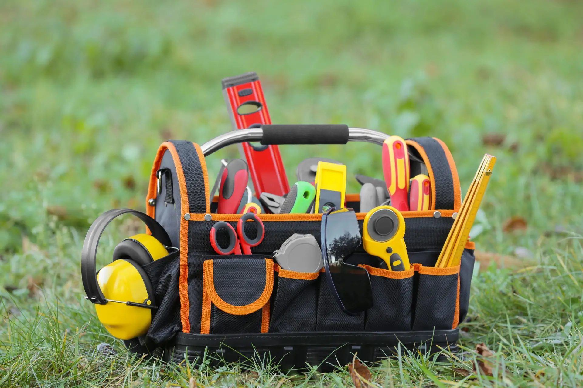 An Urgent Pro handyman provider in Sydney laying out a professional handyman toolkit including drill, level, spanners and drill bits, with professional equipment visible in a realistic local service setting