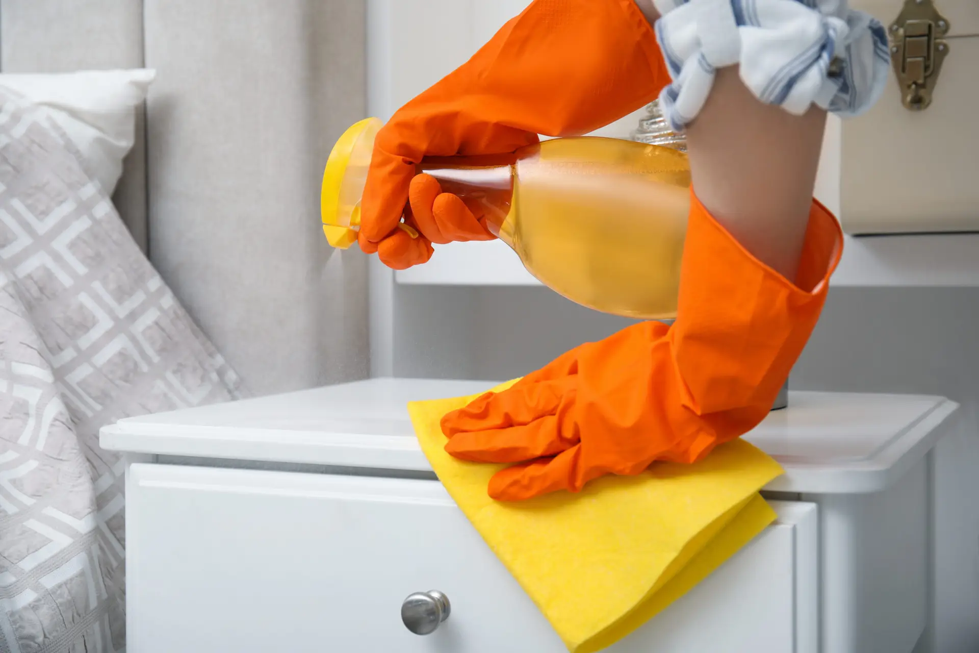 An Urgent Pro house cleaning provider in Brisbane vacuuming the bedroom floor, dusting the bedside table and wiping window sills in a Brisbane home bedroom, with professional equipment visible in a realistic local service setting
