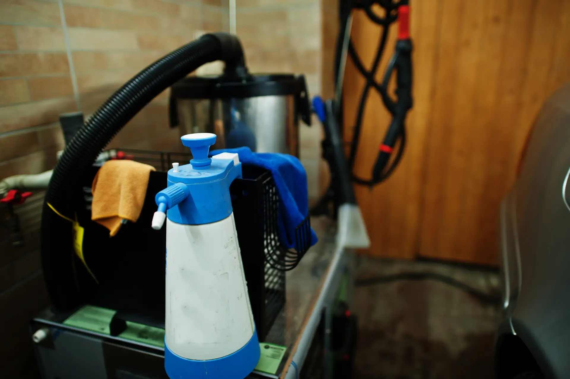 An Urgent Pro house cleaning provider in Brisbane organising eco-friendly cleaning products, mop, vacuum and cloths in a Brisbane home hallway before the service, with professional equipment visible in a realistic local service setting