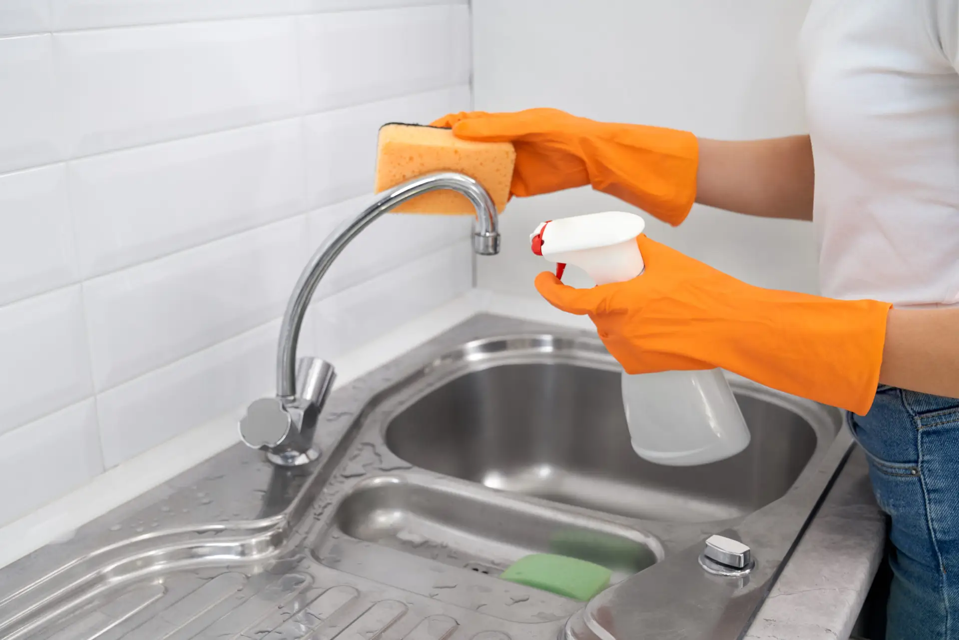 An Urgent Pro house cleaning provider in Brisbane wiping kitchen benches, appliance fronts and cupboard doors in an occupied Brisbane family home, with professional equipment visible in a realistic local service setting