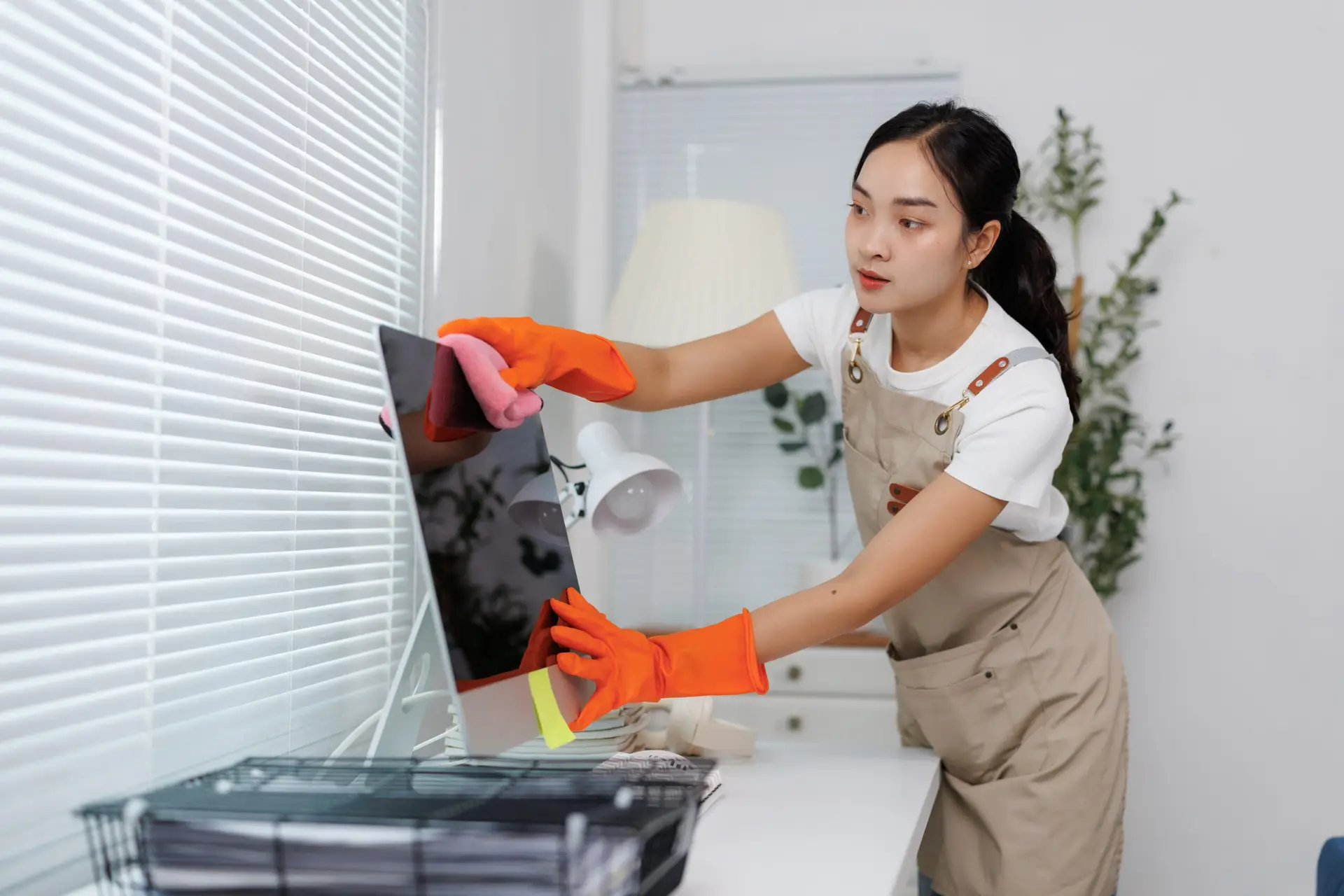 An Urgent Pro house cleaning provider in Brisbane vacuuming the sofa, dusting shelves and wiping the coffee table in a Brisbane family living room, with professional equipment visible in a realistic local service setting