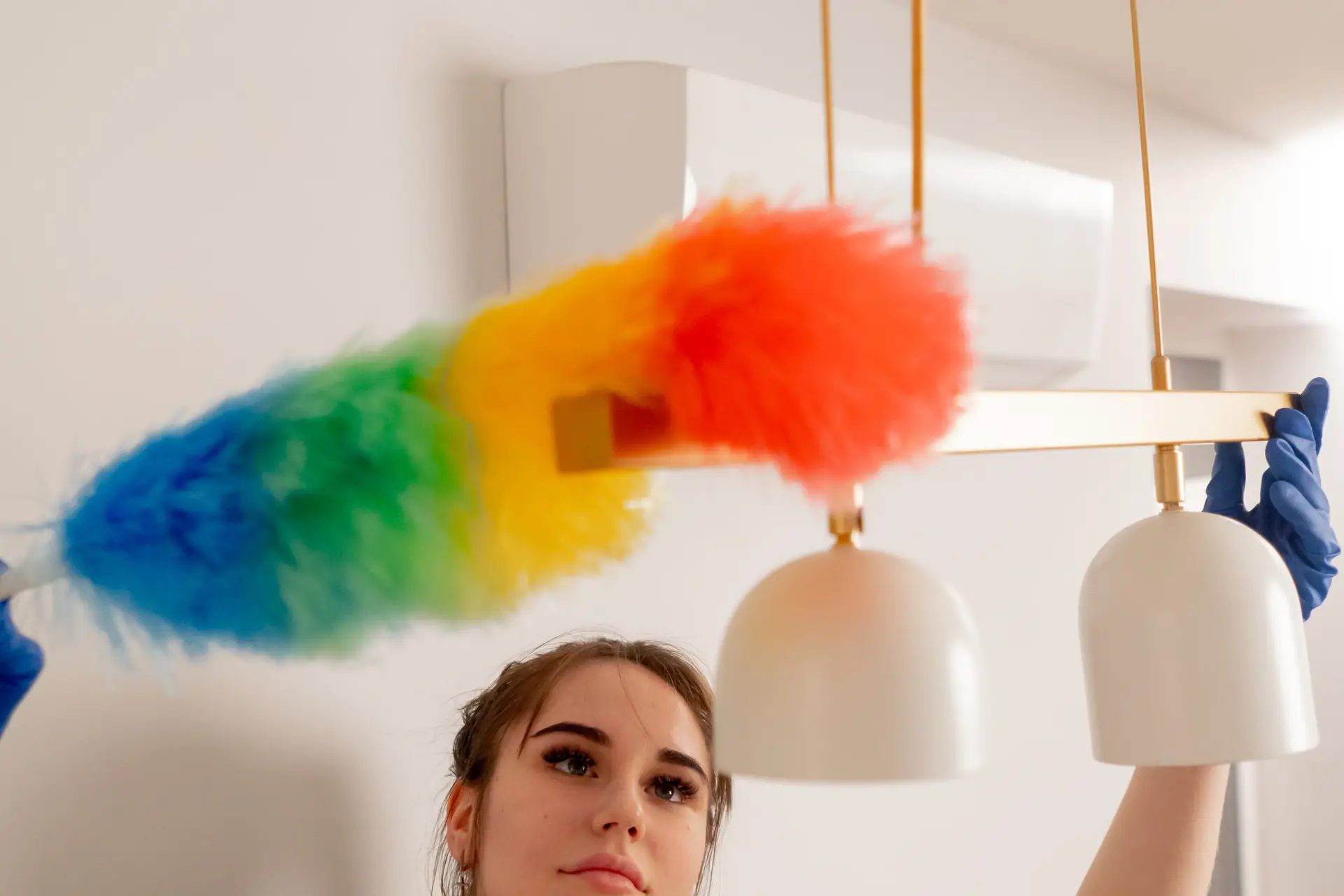 An Urgent Pro house cleaning provider in Melbourne vacuuming the sofa, dusting shelves and wiping the coffee table in a Melbourne family living room, with professional equipment visible in a realistic local service setting