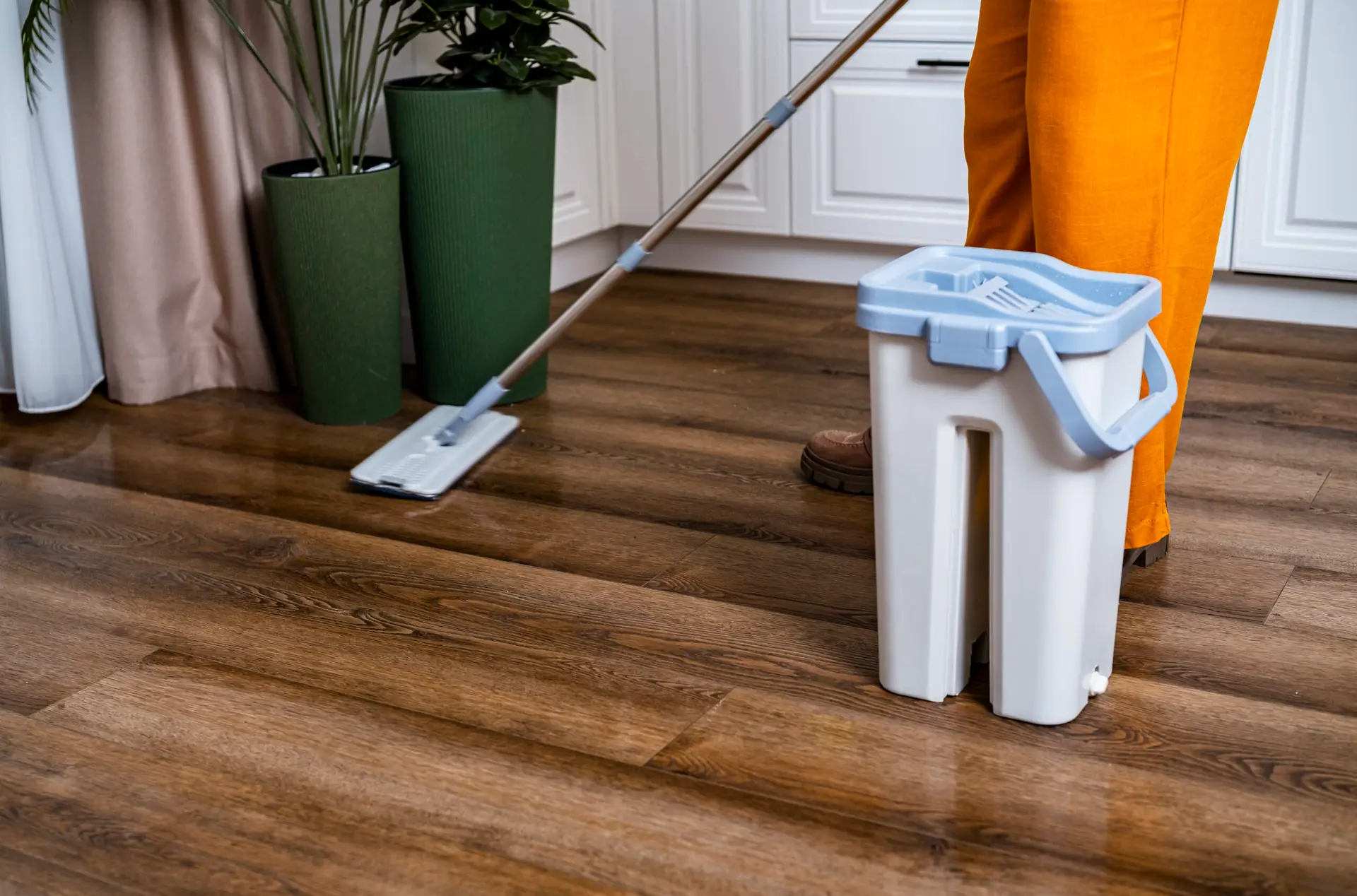 An Urgent Pro house cleaning provider in Melbourne wiping the dining table, cleaning the stovetop and tidying benchtops during a weekly Melbourne house clean, with professional equipment visible in a realistic local service setting
