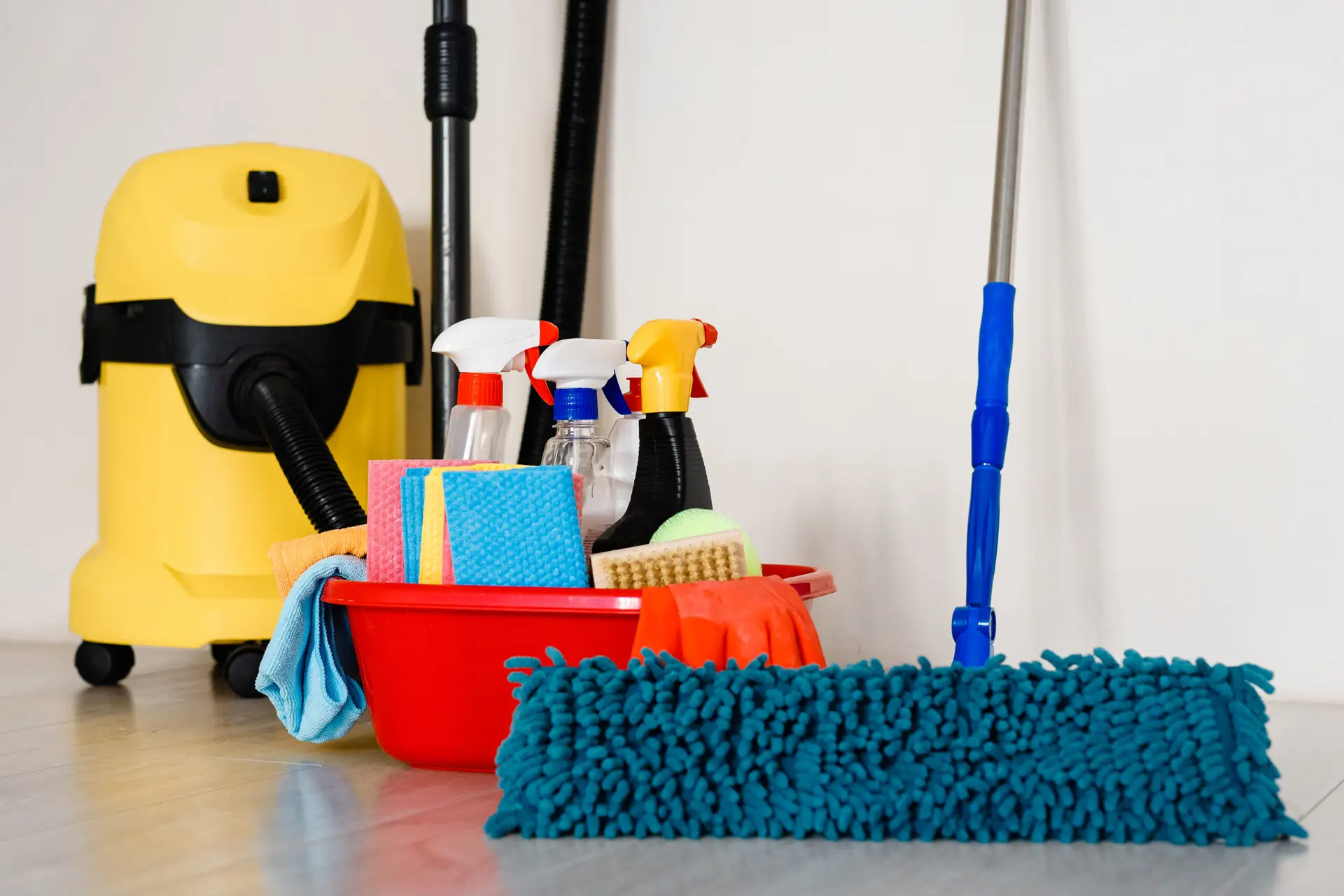 An Urgent Pro house cleaning provider in Sydney organising eco-friendly cleaning products, mop, vacuum and cloths in a Sydney home hallway before the service, with professional equipment visible in a realistic local service setting
