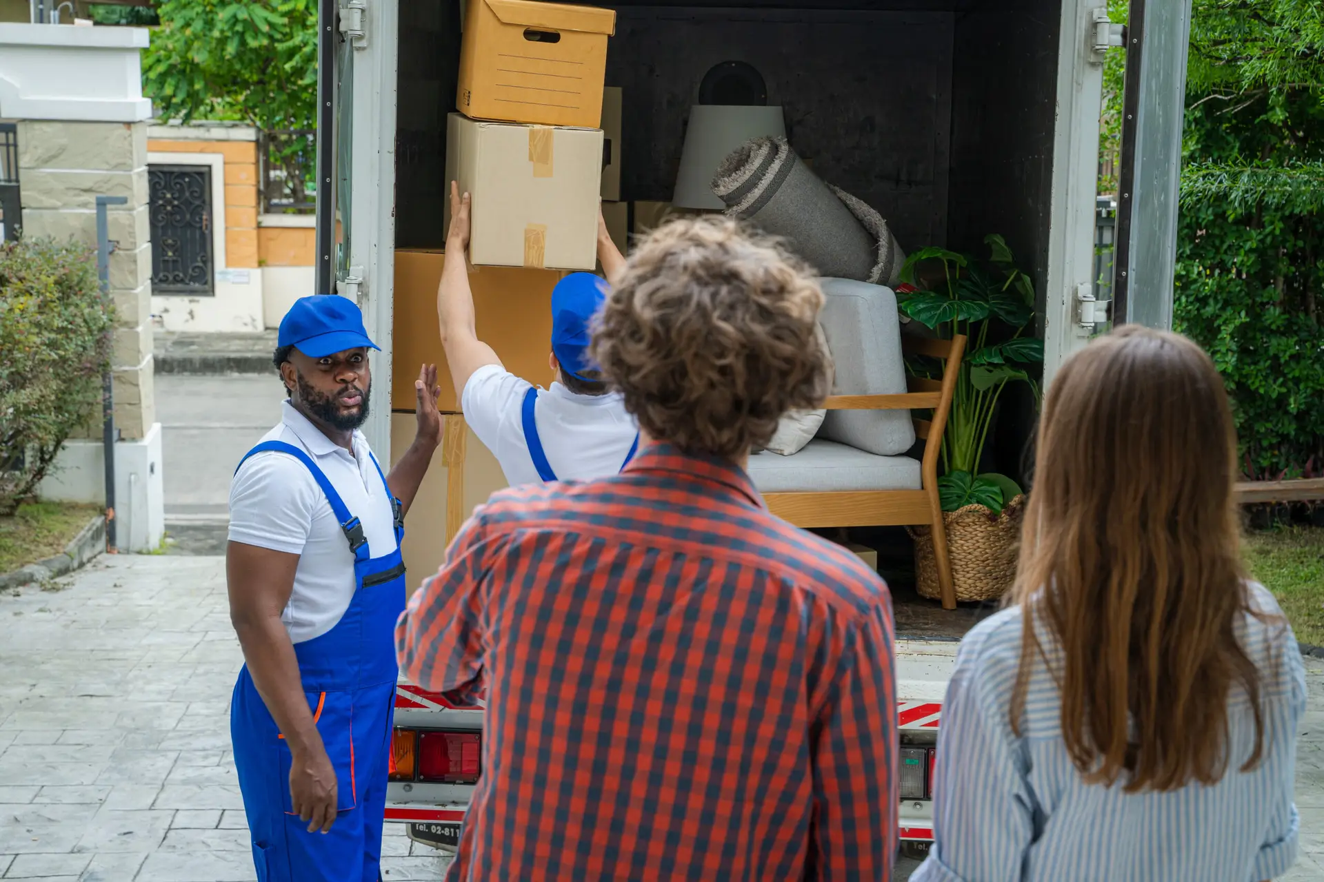 An Urgent Pro house removalists provider in Brisbane standing beside a fully loaded removal truck parked outside a home ready to depart, with professional equipment visible in a realistic local service setting
