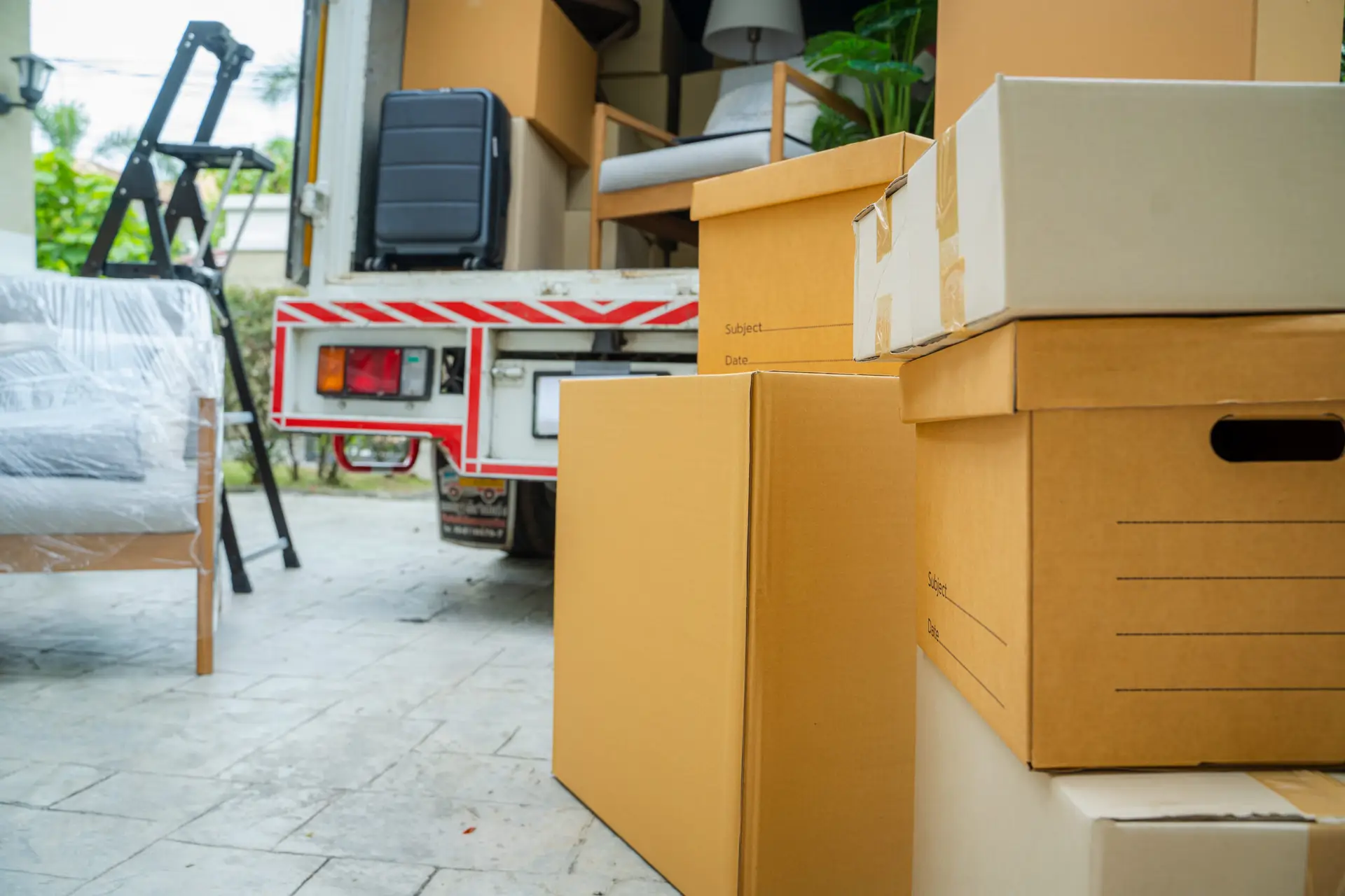 An Urgent Pro house removalists provider in Gold Coast carrying furniture items into a new home through the front door during the delivery stage, with professional equipment visible in a realistic local service setting
