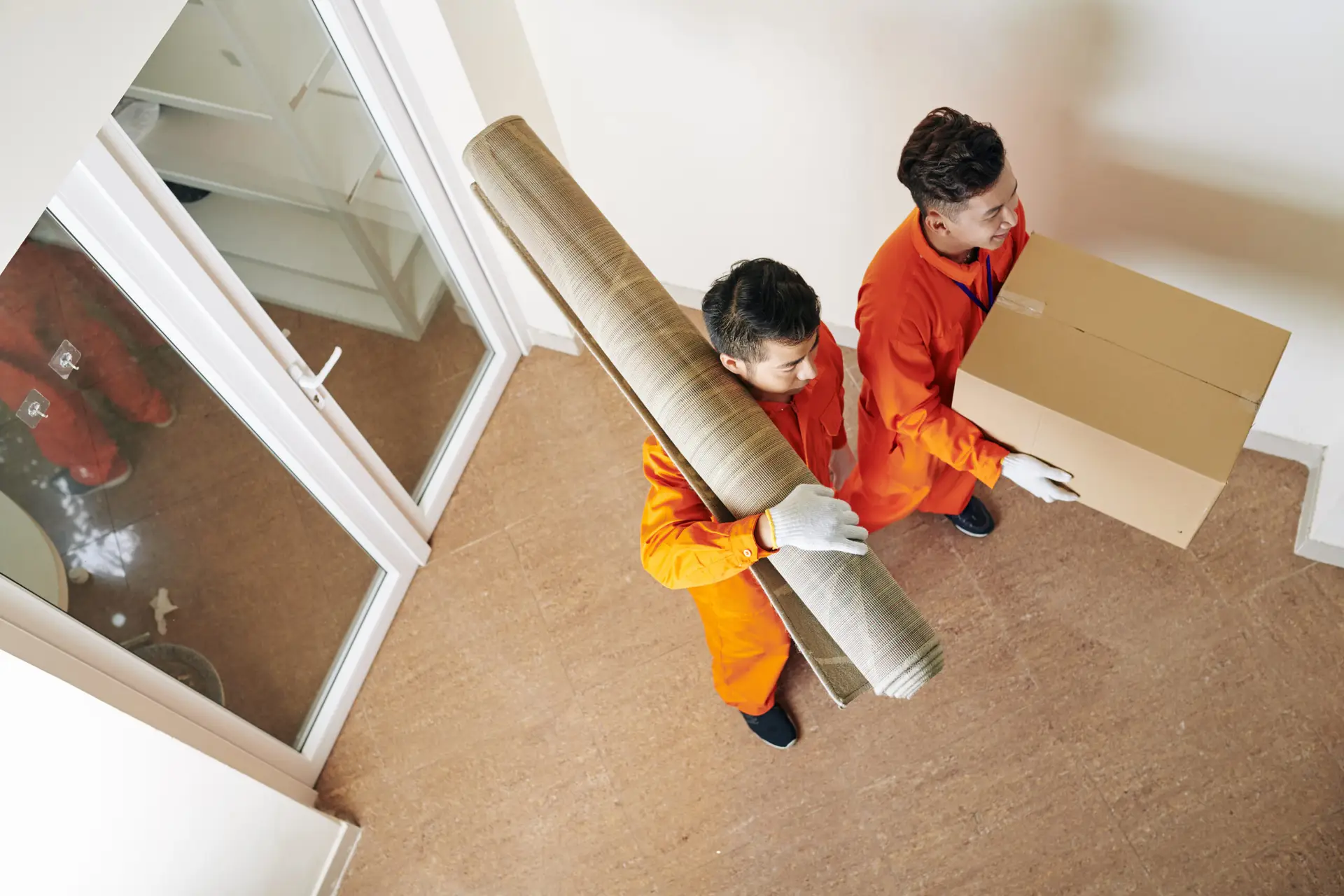 An Urgent Pro house removalists provider in Melbourne carrying furniture items into a new home through the front door during the delivery stage, with professional equipment visible in a realistic local service setting