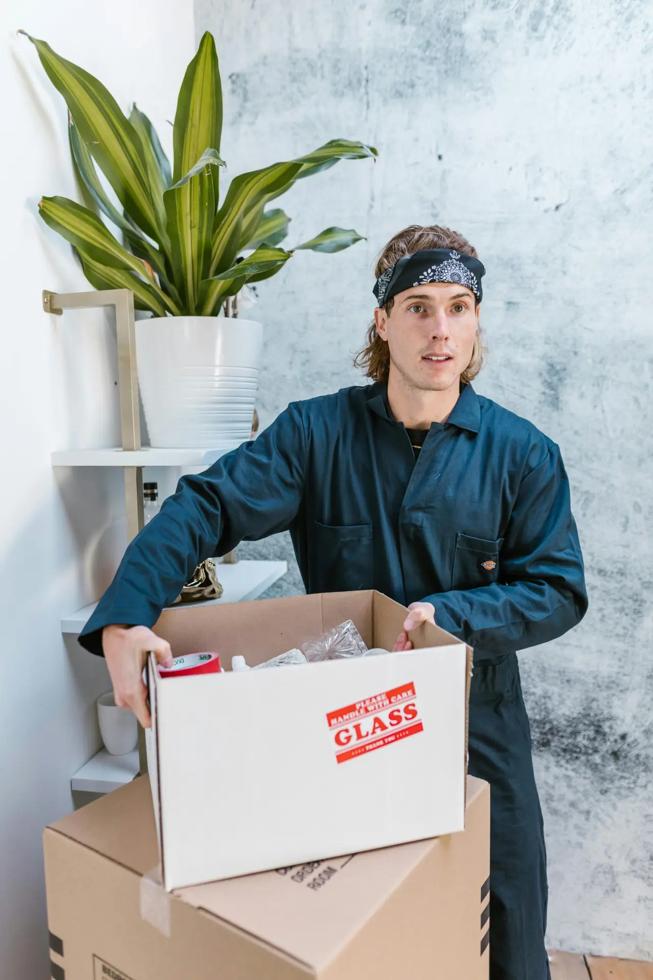 An Urgent Pro house removalists provider in Melbourne carefully loading fragile glass-front furniture with padding into the removal truck, with professional equipment visible in a realistic local service setting