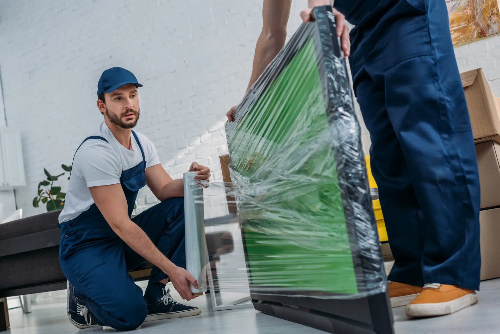An Urgent Pro house removalists provider in Perth carefully loading fragile glass-front furniture with padding into the removal truck, with professional equipment visible in a realistic local service setting