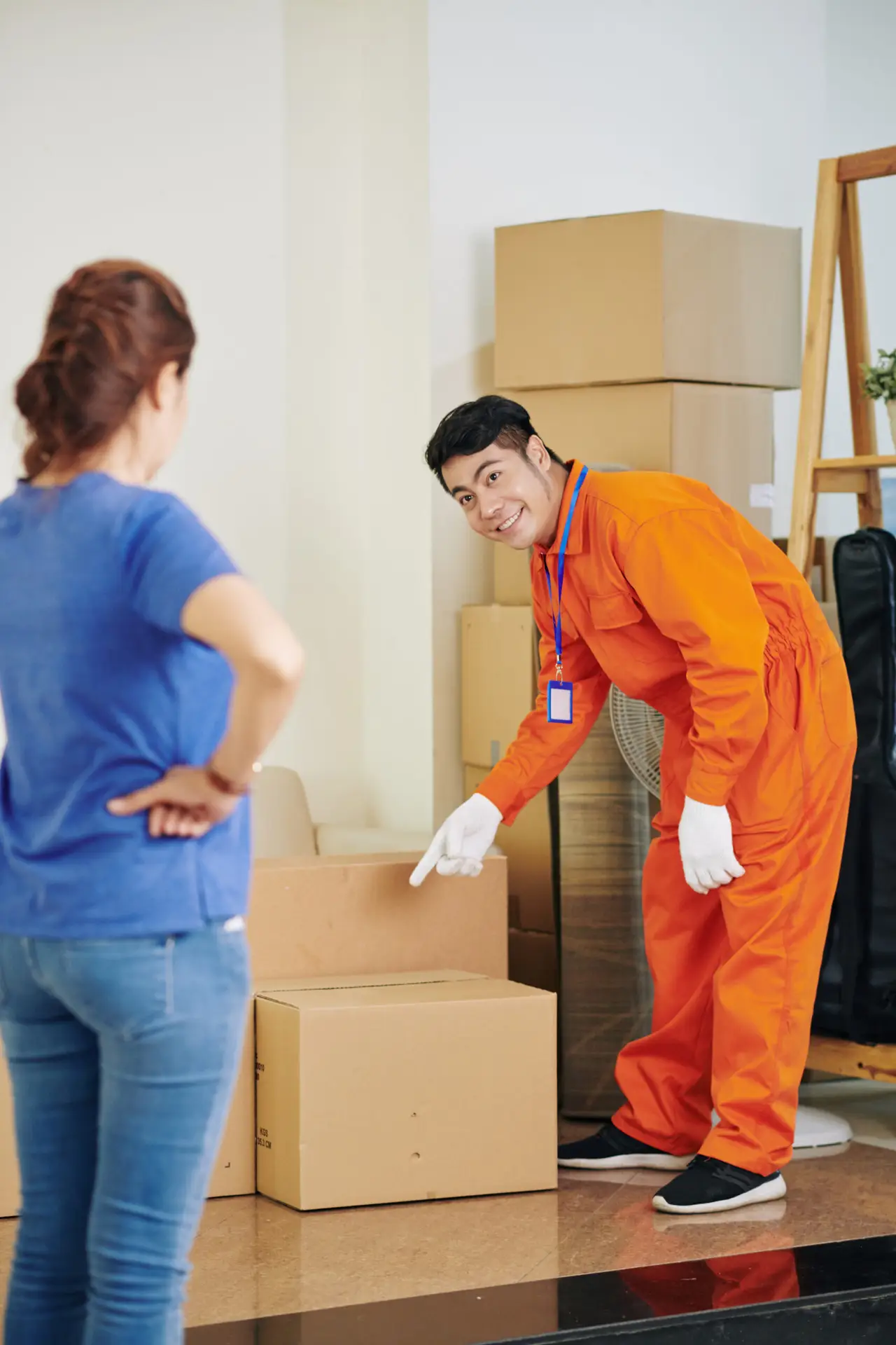 An Urgent Pro house removalists provider in Sydney stacking and labelling cardboard moving boxes in a room ready for efficient loading, with professional equipment visible in a realistic local service setting