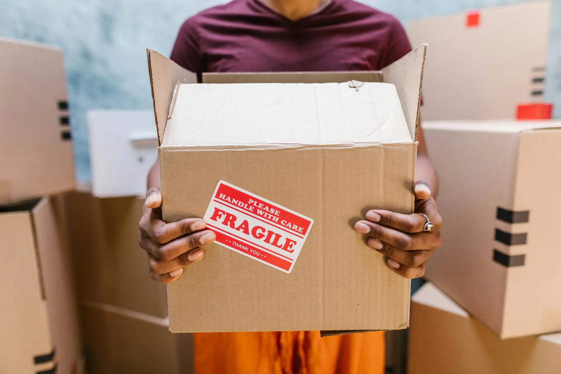 An Urgent Pro house removalists provider in Sydney carefully loading fragile glass-front furniture with padding into the removal truck, with professional equipment visible in a realistic local service setting