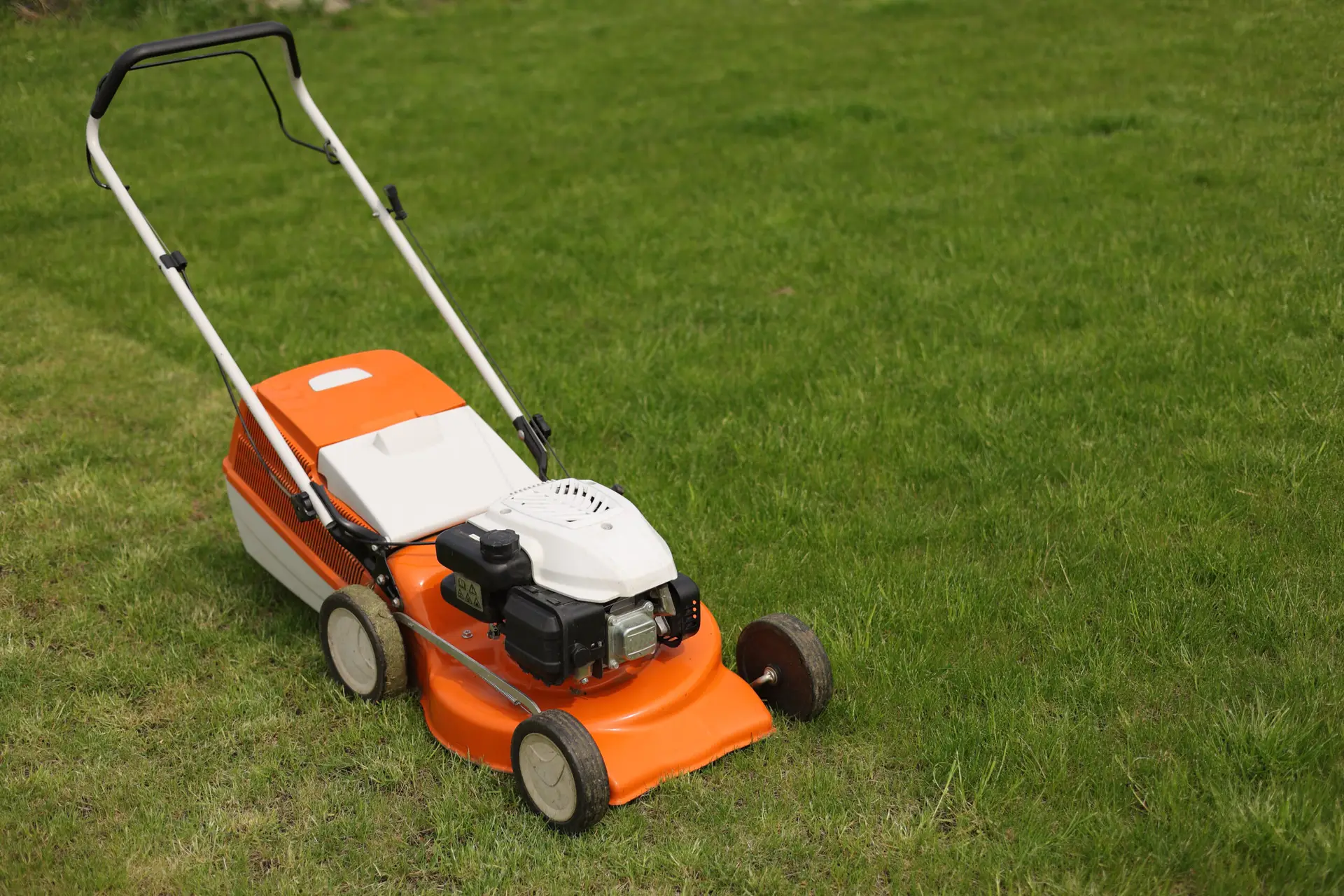 An Urgent Pro lawn mowing provider in Gold Coast laying out professional mowing equipment including mower, trimmer, blower and shears before the job, with professional equipment visible in a realistic local service setting