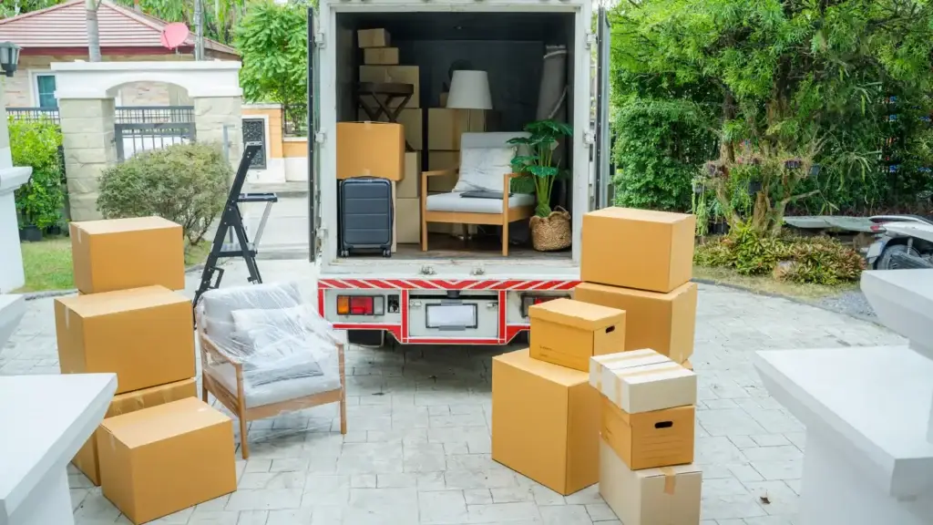 Removalist truck being loaded with furniture and boxes outside a residential property for an interstate move
