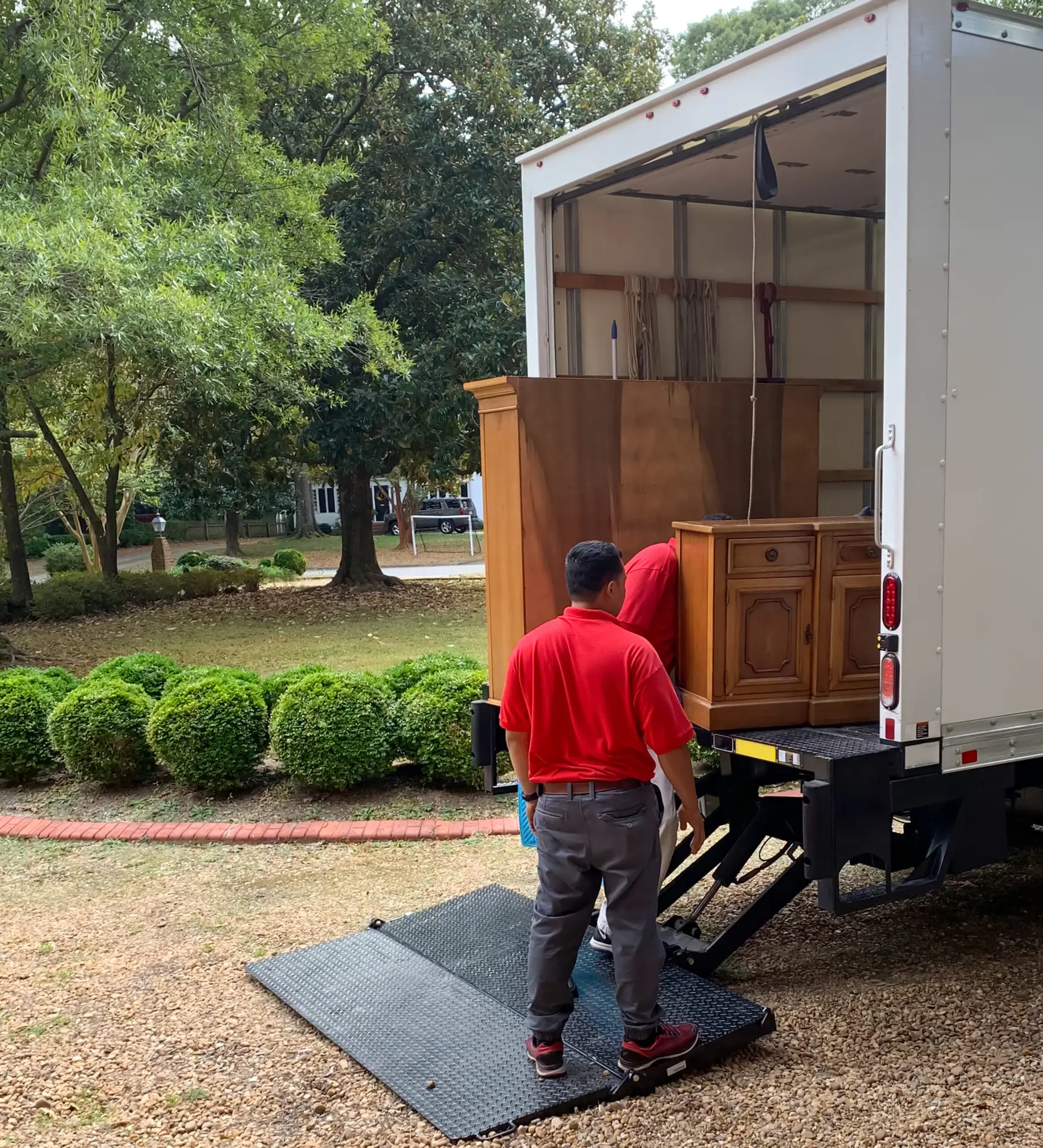 An Urgent Pro rubbish removal provider in Brisbane removing an old sofa, armchair and table from a property for disposal and responsible recycling, with professional equipment visible in a realistic local service setting
