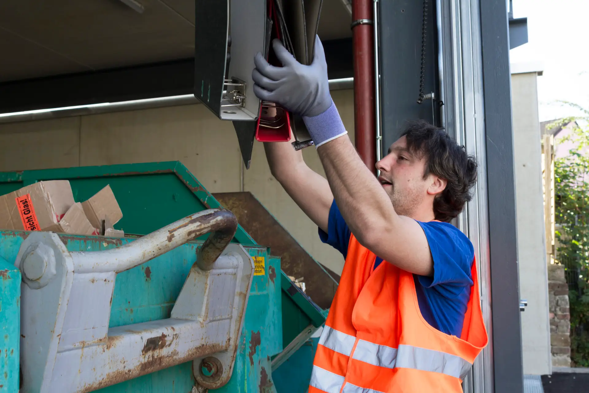 An Urgent Pro rubbish removal provider in Brisbane loading household junk and garden waste onto a rubbish removal truck outside a residential property, with professional equipment visible in a realistic local service setting
