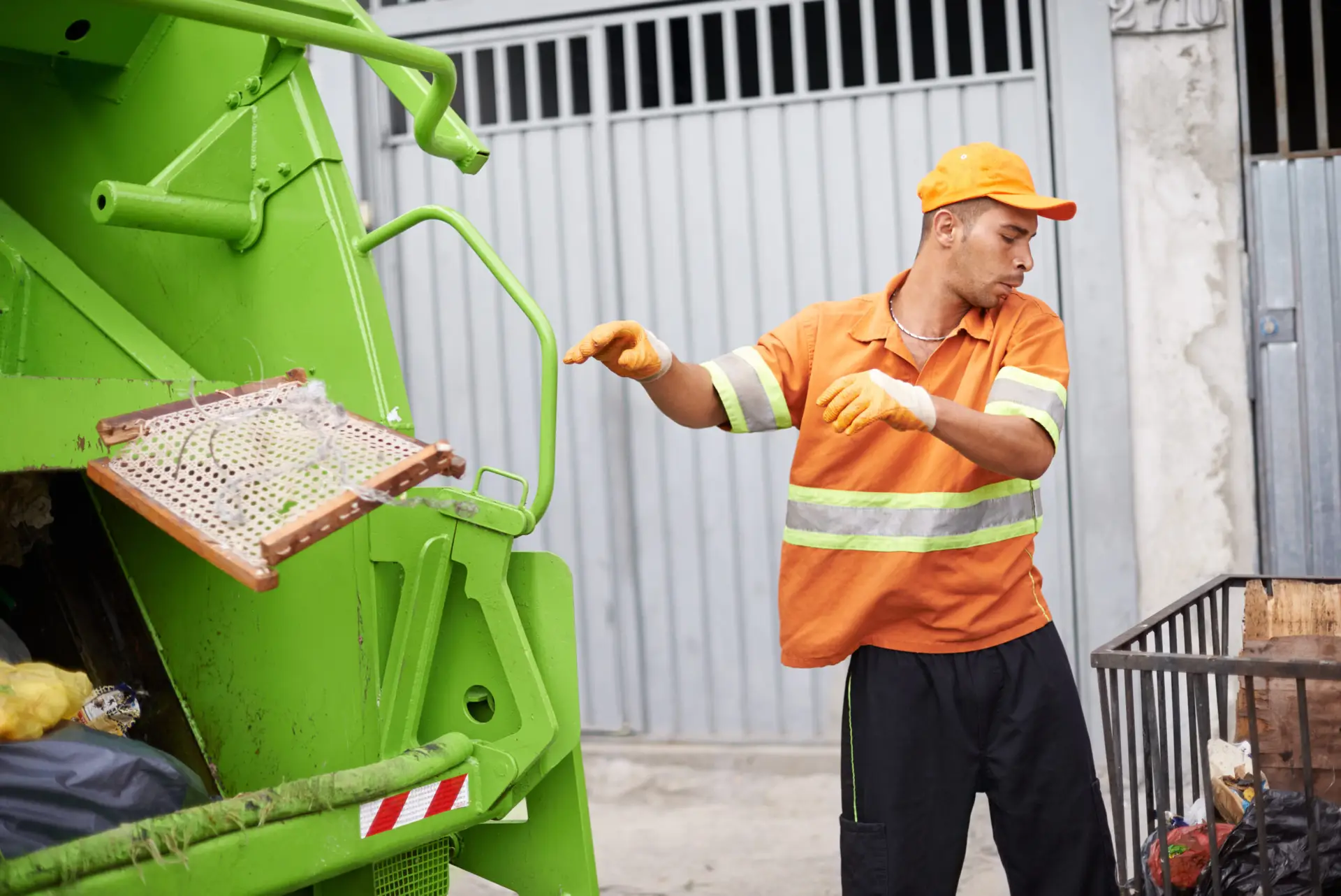 An Urgent Pro rubbish removal provider in Gold Coast loading household junk and garden waste onto a rubbish removal truck outside a residential property, with professional equipment visible in a realistic local service setting