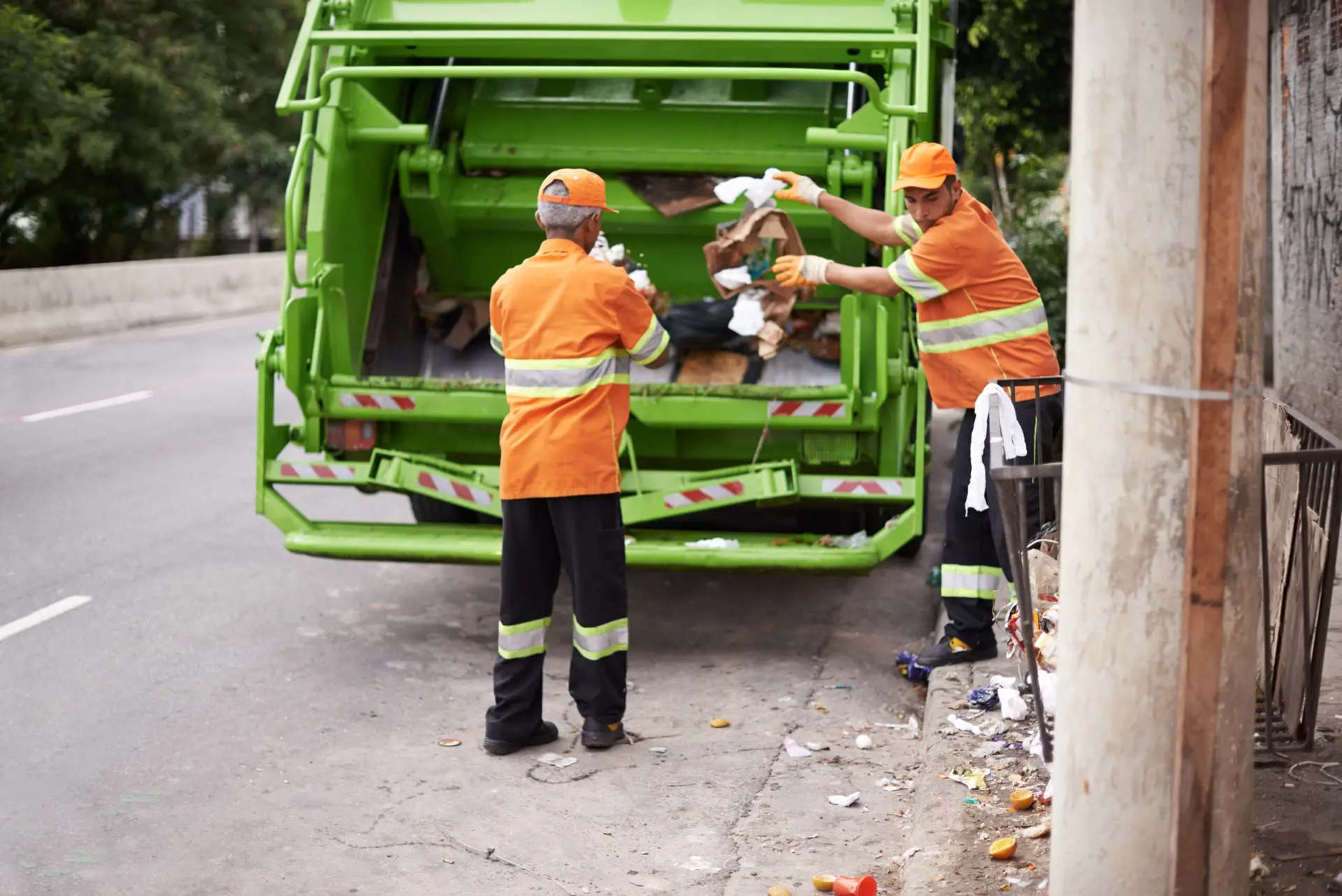 An Urgent Pro rubbish removal provider in Melbourne loading household junk and garden waste onto a rubbish removal truck outside a residential property, with professional equipment visible in a realistic local service setting