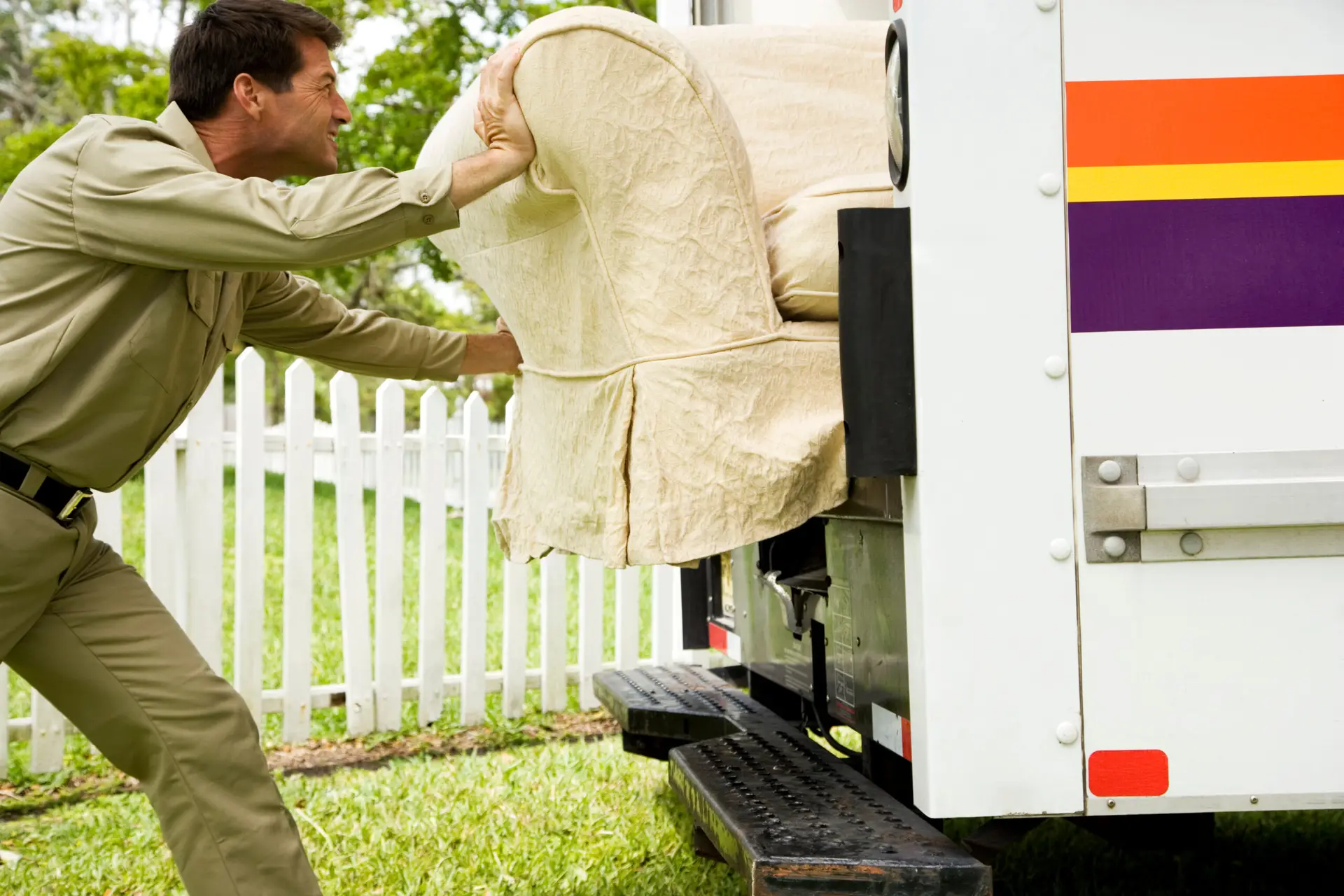 An Urgent Pro rubbish removal provider in Perth removing an old sofa, armchair and table from a property for disposal and responsible recycling, with professional equipment visible in a realistic local service setting