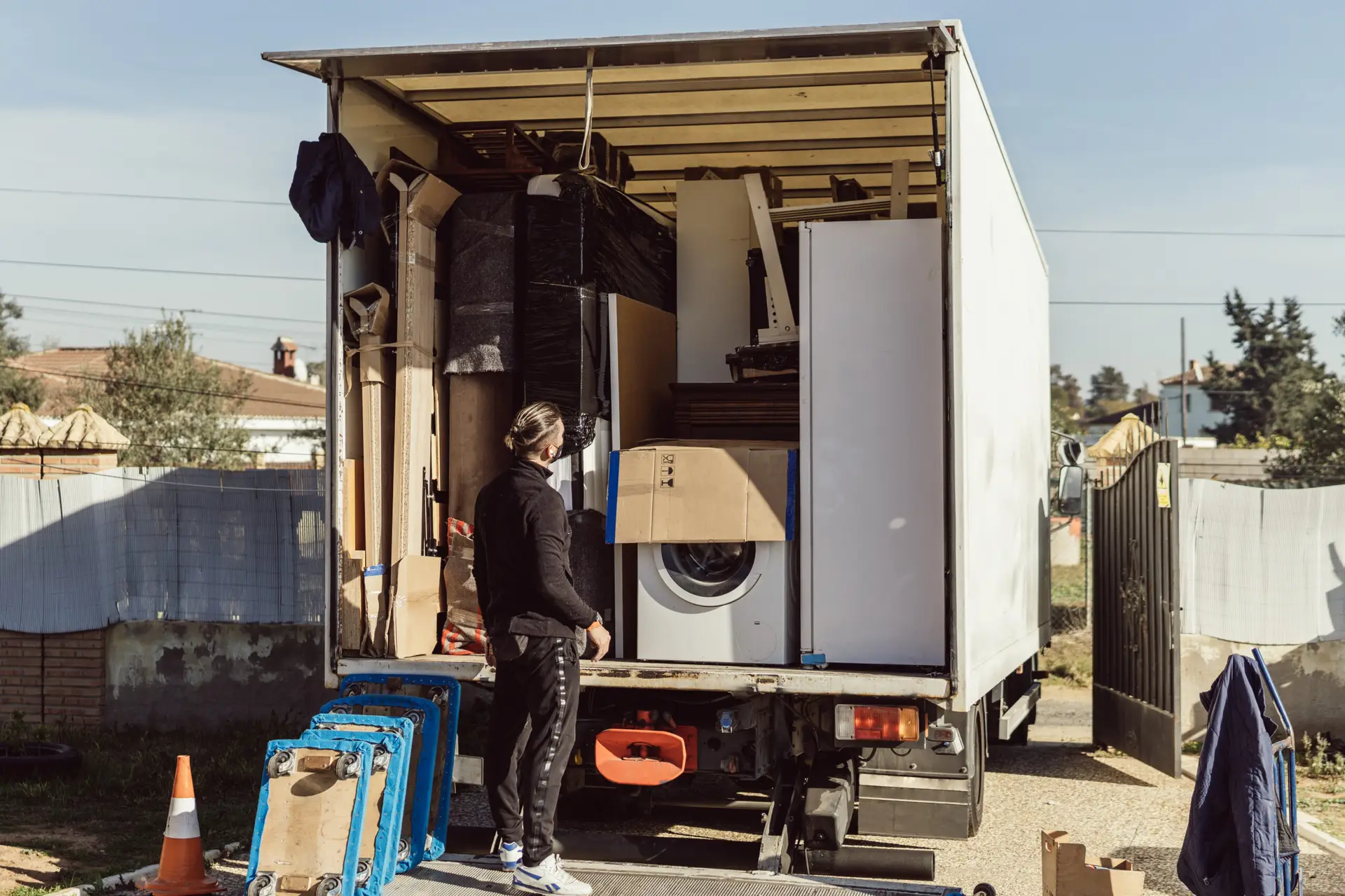 An Urgent Pro rubbish removal provider in Sydney lifting an old fridge-freezer out of a kitchen and loading it safely onto the truck for recycling, with professional equipment visible in a realistic local service setting