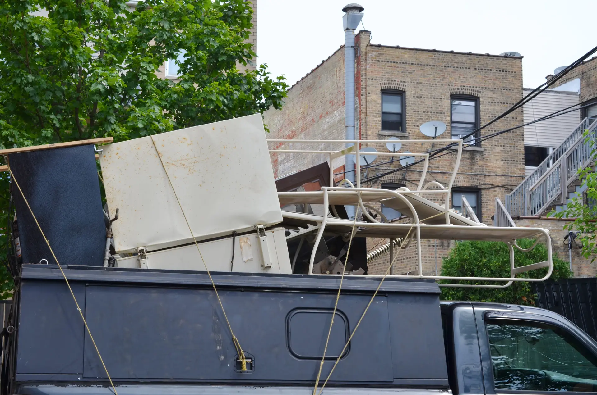 An Urgent Pro rubbish removal provider in Sydney removing an old sofa, armchair and table from a property for disposal and responsible recycling, with professional equipment visible in a realistic local service setting
