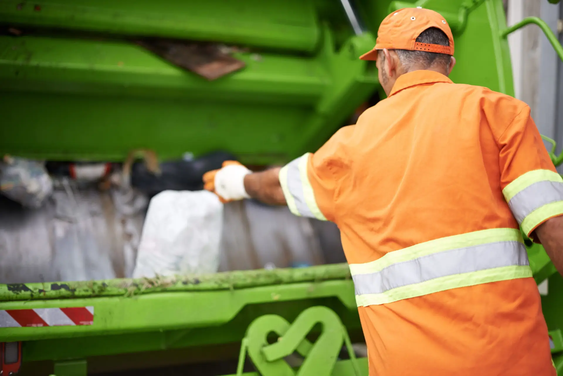 An Urgent Pro rubbish removal provider in Sydney loading household junk and garden waste onto a rubbish removal truck outside a residential property, with professional equipment visible in a realistic local service setting
