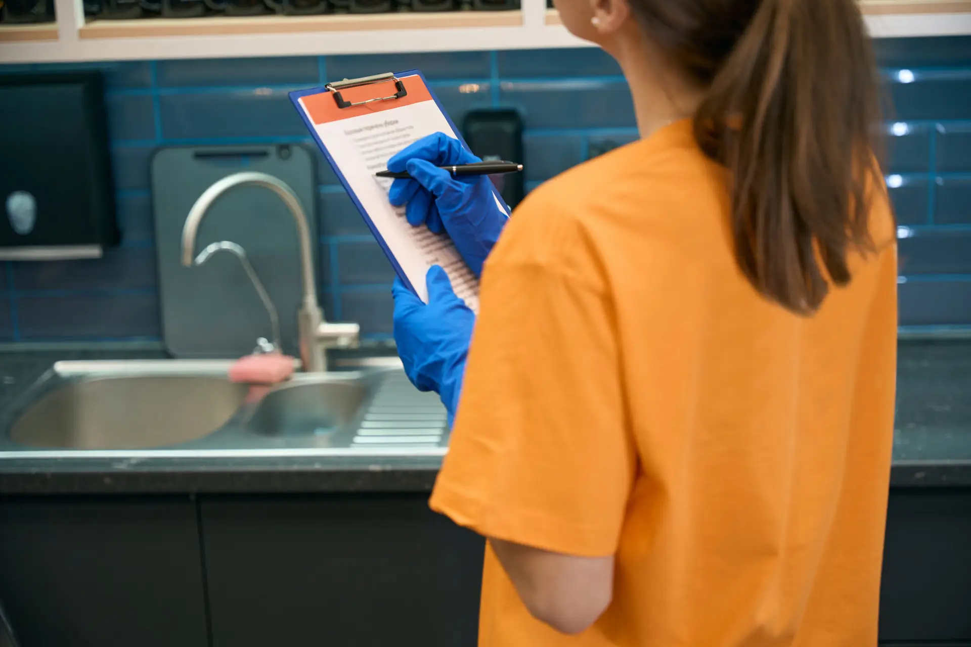 An Urgent Pro team member doing a final room-by-room walk of a Brisbane rental property with a clipboard, checking that each surface including light switches, power points and door frames meets the required cleaning standard before the outgoing inspection