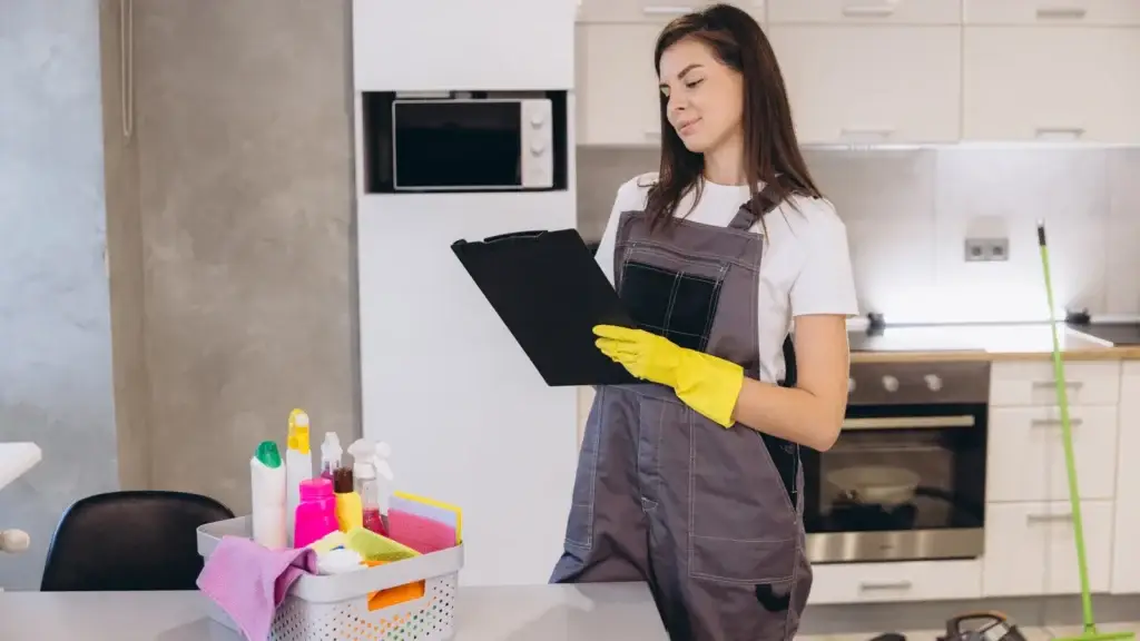 Cleaner wiping kitchen benchtops during a vacate clean in a Perth rental