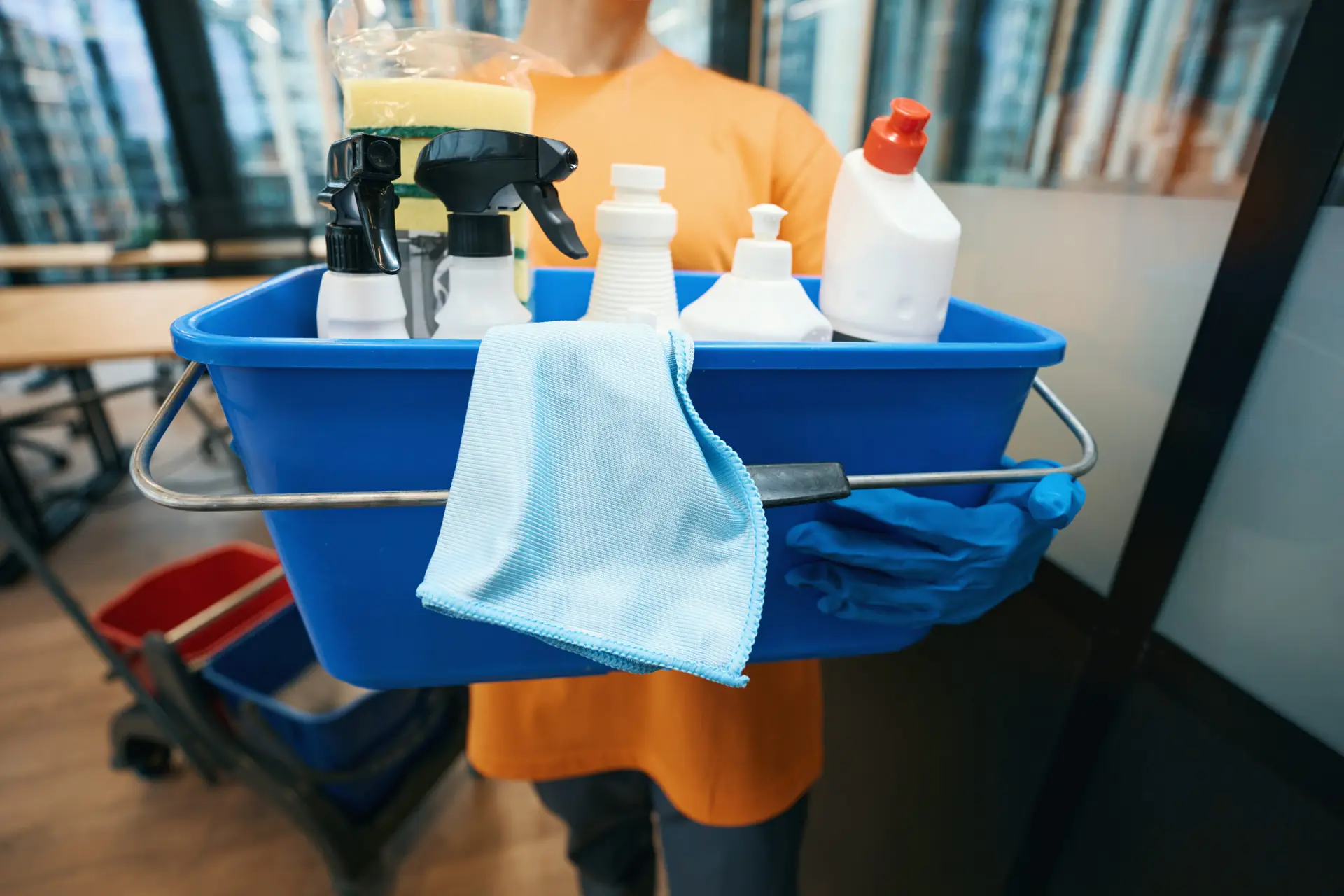 An Urgent Pro cleaner arriving at a Melbourne rental property carrying a well-stocked cleaning caddy and a mop, wearing a clean uniform and ready to begin the vacate clean for a tenant who has handed over access