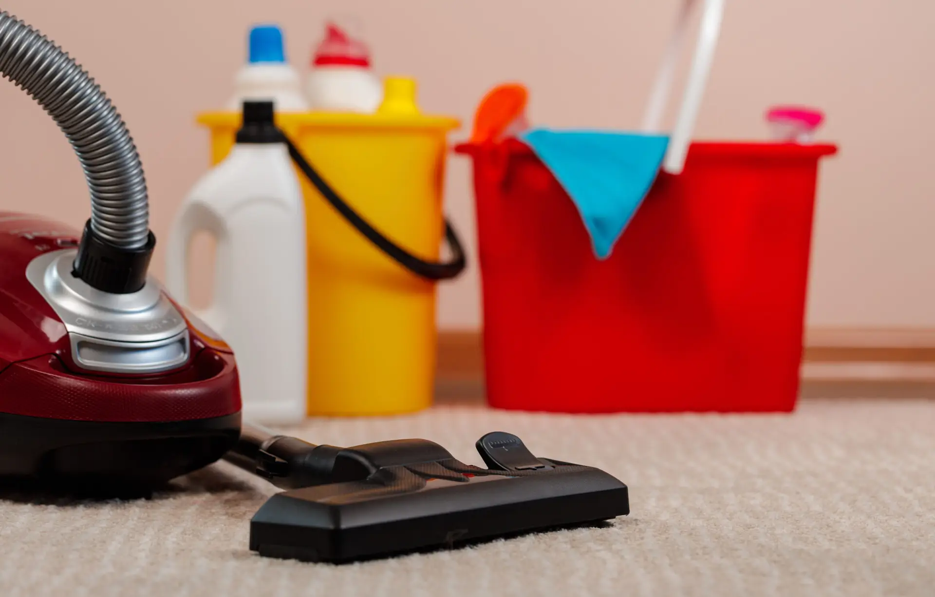 A complete vacate cleaning kit laid out on the floor of a Sydney rental property entry — including spray bottles of cleaning products, microfibre cloths, a mop, a vacuum, a scrubbing brush and rubber gloves arranged neatly before the job begins